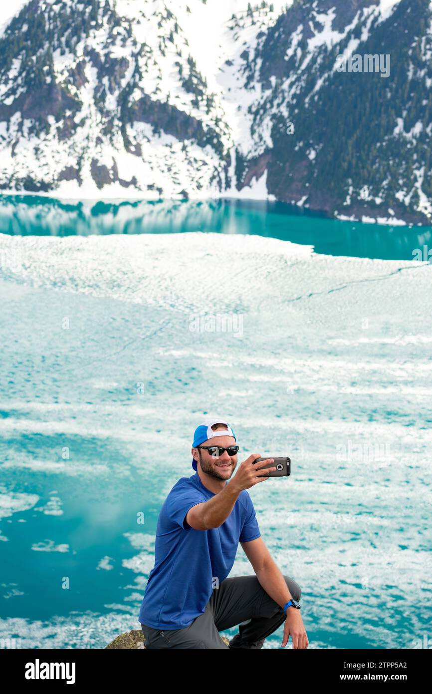 L'escursionista cattura un selfie con lo splendido blu del lago Garibaldi. Foto Stock