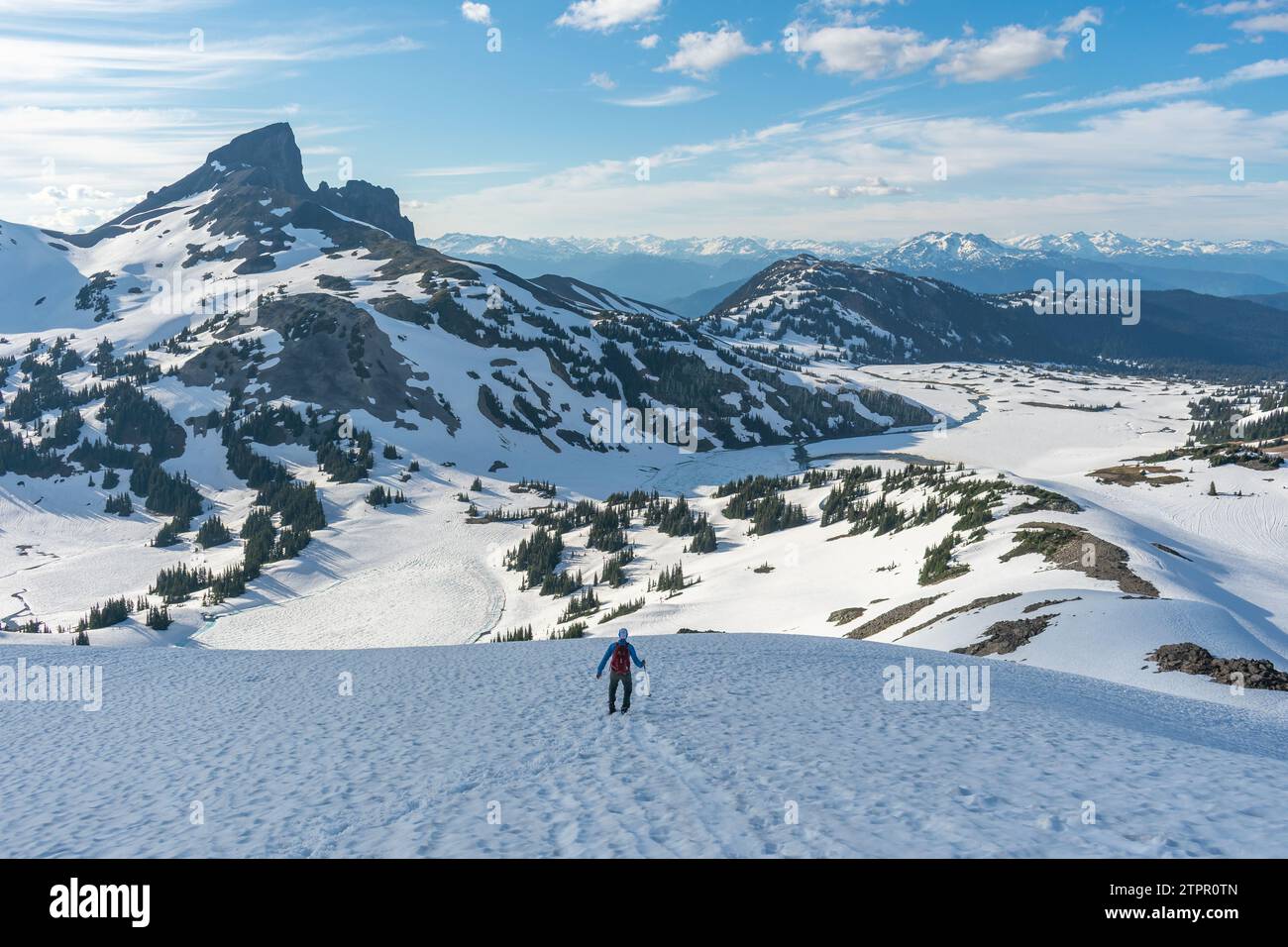 Escursionista con racchette da neve a Panorama Ridge con Black Tusk in lontananza. Foto Stock