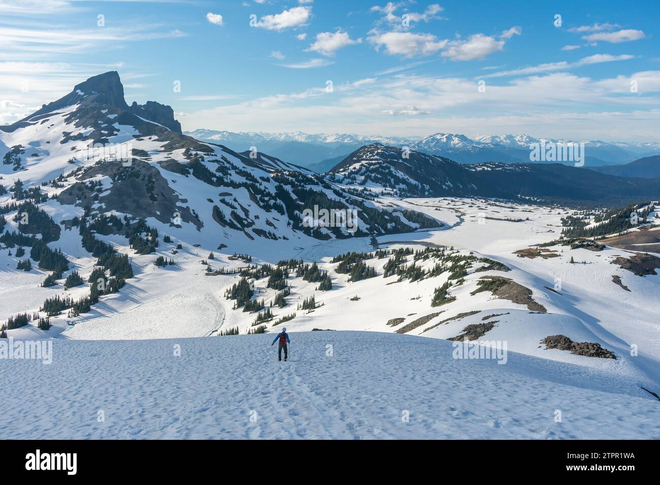 Escursionista con racchette da neve a Panorama Ridge con Black Tusk in lontananza. Foto Stock