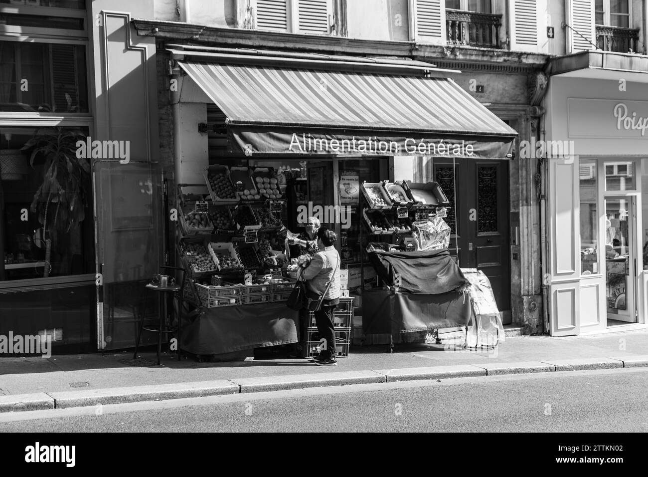 Donna che compra frutta in un negozio di alimentari in strada, Parigi, Francia Foto Stock
