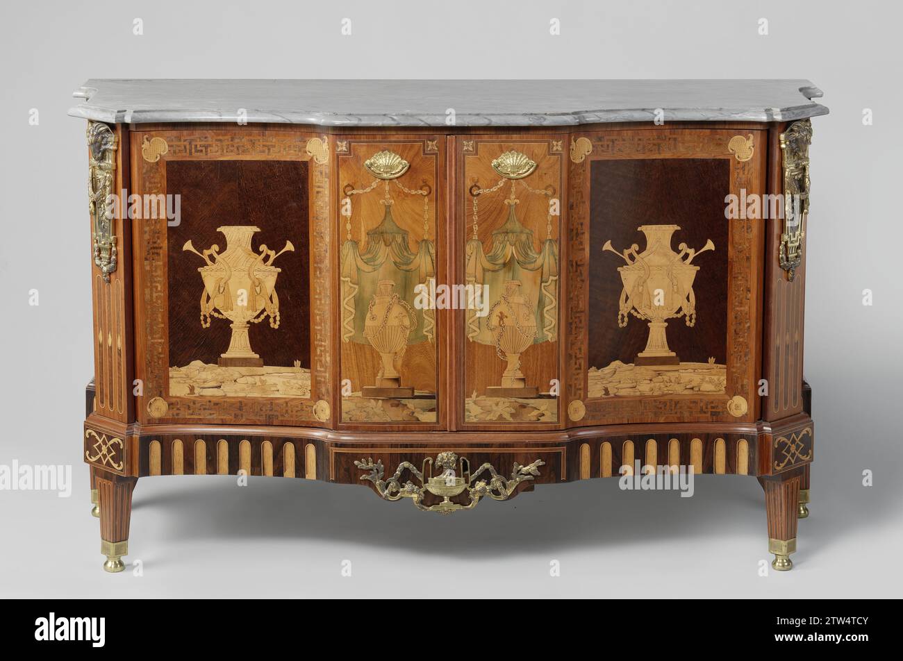 Commode e due armadi, anonimi, 1770 - 1790 READE DI LEGNO DI QUERCIA, incollato con legni diversi e dotato di pastella di rame dorato e foglia di marmo grigio-bianco-venato. Lo scafo si trova su una base separata con gambe quadrate appoggiate su piedini metallici. I vasi di Marqueterie sono stati installati sulle due porte e al centro della parte anteriore. Ai lati del comò, vengono visualizzati dei semplici trofei sospesi di una freccia e di una torcia. L'asse nel comò è stato sudato al centro, in modo che un oggetto alto possa essere posizionato sul fondo. Quercia olandese (legno). rosewood (legno). rosewood (legno). Foto Stock
