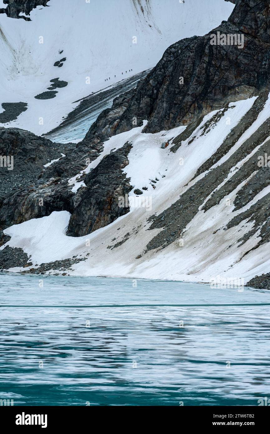 Il forte contrasto tra le acque ghiacciate del lago Wedgemount e l'aspro sfondo montano. Foto Stock