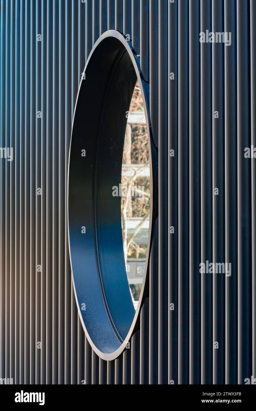 Riflessi in una finestra circolare incorporata in una parete di acciaio allineata verticalmente, parte del nuovo Plaza Building progettato da Adjaye Associates a Sydney, Aust. Foto Stock