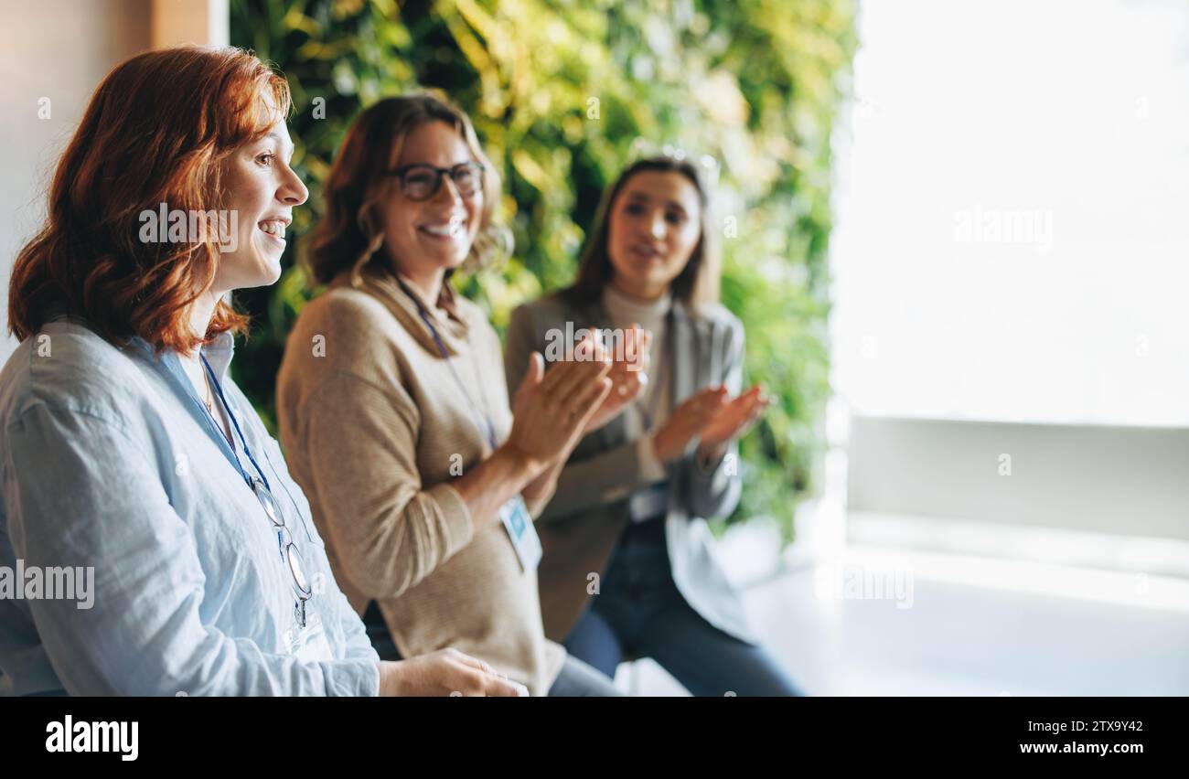 I professionisti del multitasking applaudono e celebrano una riunione di successo. L'ambiente dell'ufficio è pieno di lavoro di squadra e collaborazione come co Foto Stock
