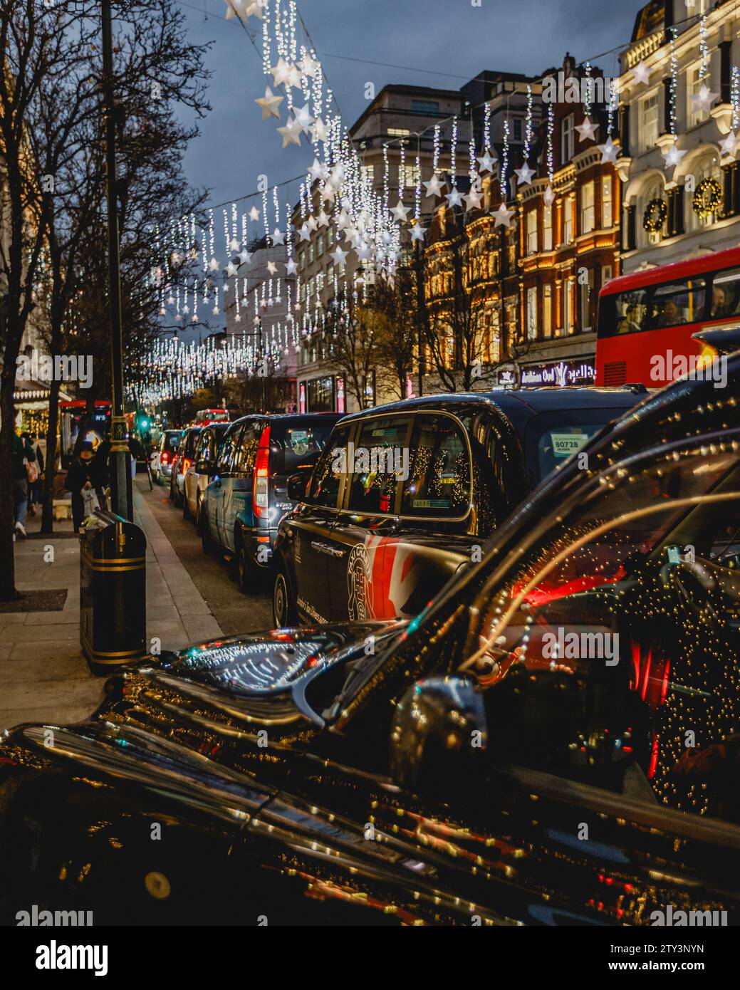 Durante le festività natalizie, molti taxi fanno la fila per le tariffe fuori dal Selfridge's di Londra. Foto Stock
