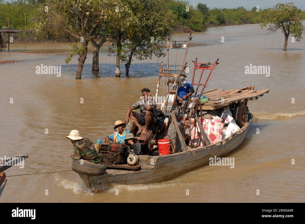 Lavoratori agricoli che trasportano macchinari in barca, villaggio galleggiante Kampong Phluk nel lago Tonle SAP, Cambogia, Asia. Foto Stock
