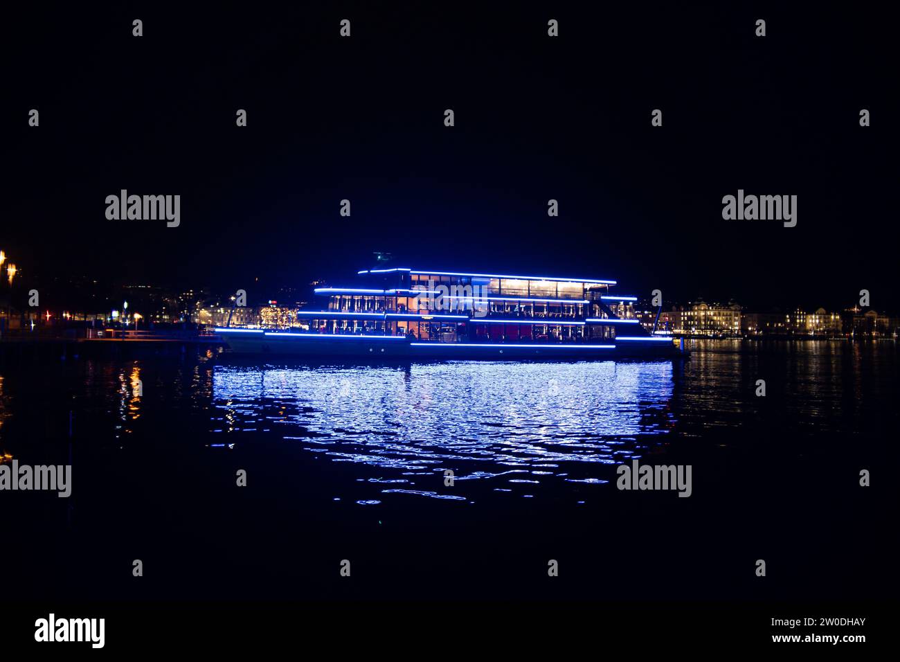 Nave passeggeri Panta Rhei attraccata sul lago di Zurigo di notte, splendide luci blu riflesse nell'acqua. Foto Stock
