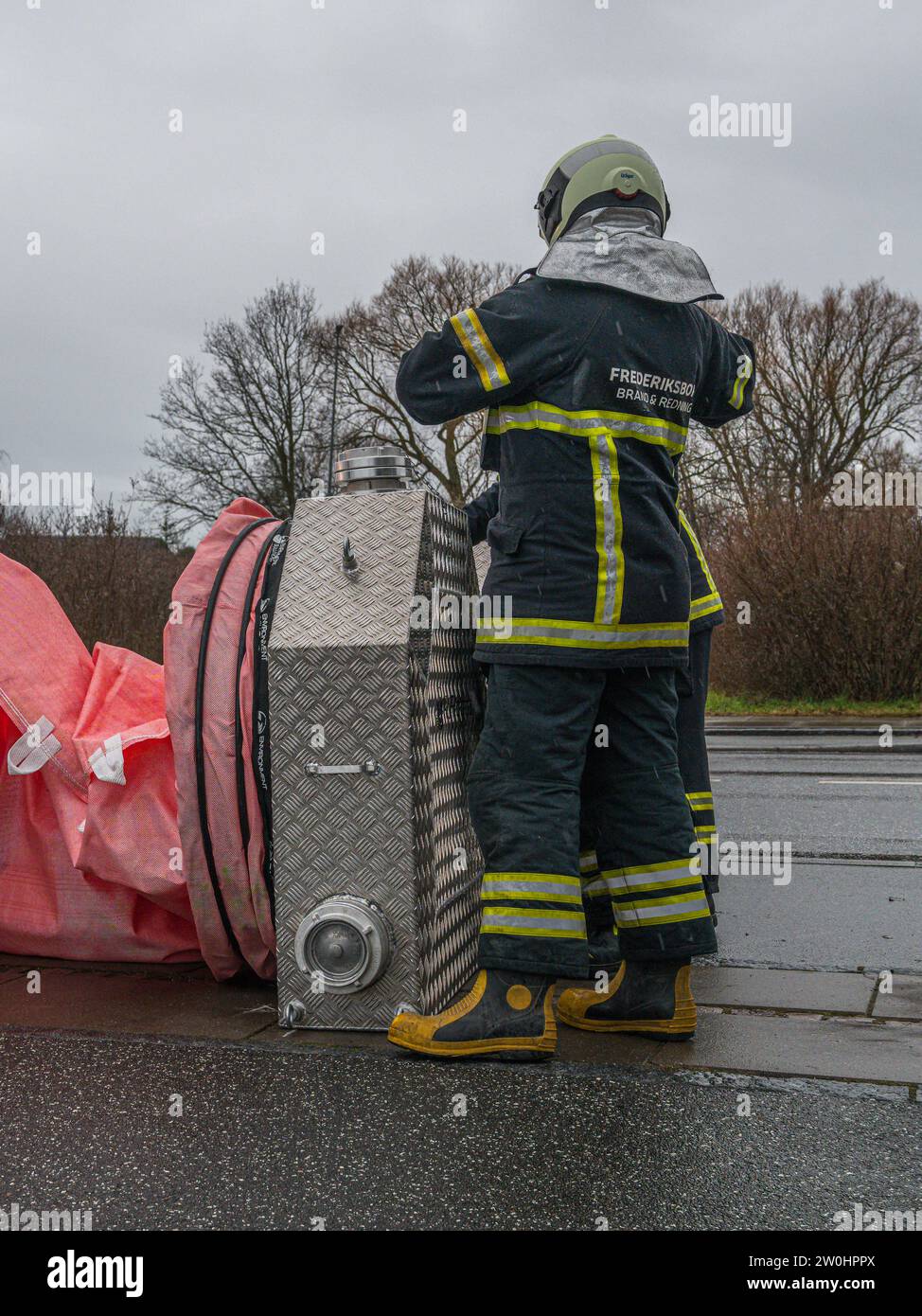 Frederikssund, Danimarca, 20 dicembre 2023. I vigili del fuoco preparano i tubi dell'acqua prima che la tempesta Pia colpisca Frederikssund Foto Stock