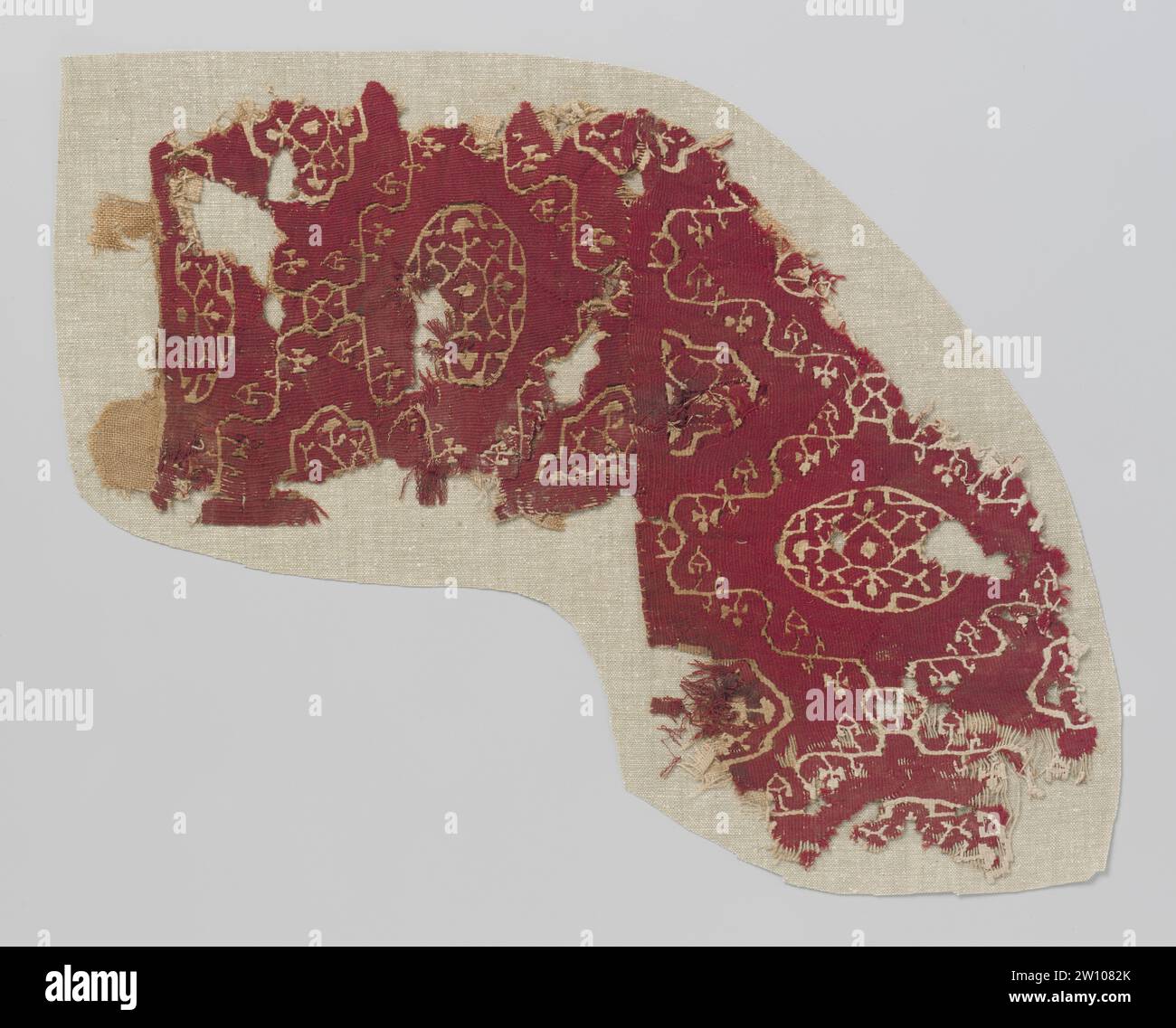 Frammento di tessuto in arazzo, anonimo, c. 500 - c. 799 frammento di tessuto costituito da due parti cucite insieme, con un motivo di colore naturale di tendini ondulati con foglie triangolari che formano un motivo di diamante avvolgente su un terreno rosso vino, in cui un medaglione con rami e linee stilizzate. Lungo un lato sono visibili due pezzi dal sibilo del substrato di lino. Egitto Ketting an Element: Lino (materiale). Ingresso: Arazzo di lana frammento di tessuto costituito da due parti cucite insieme, con un motivo di colore naturale di tendine ondulati con foglie triangolari che formano una tortuosa mot di diamante Foto Stock