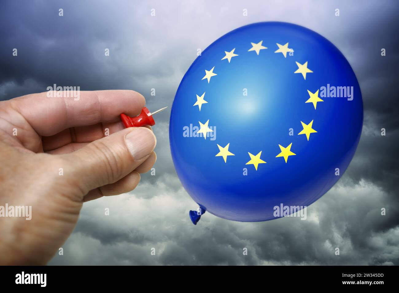 FOTOMONTAGE, EU-Ballon und Hand mit Nadel, Symbolfoto EU-Streit und Uneinigkeit Foto Stock