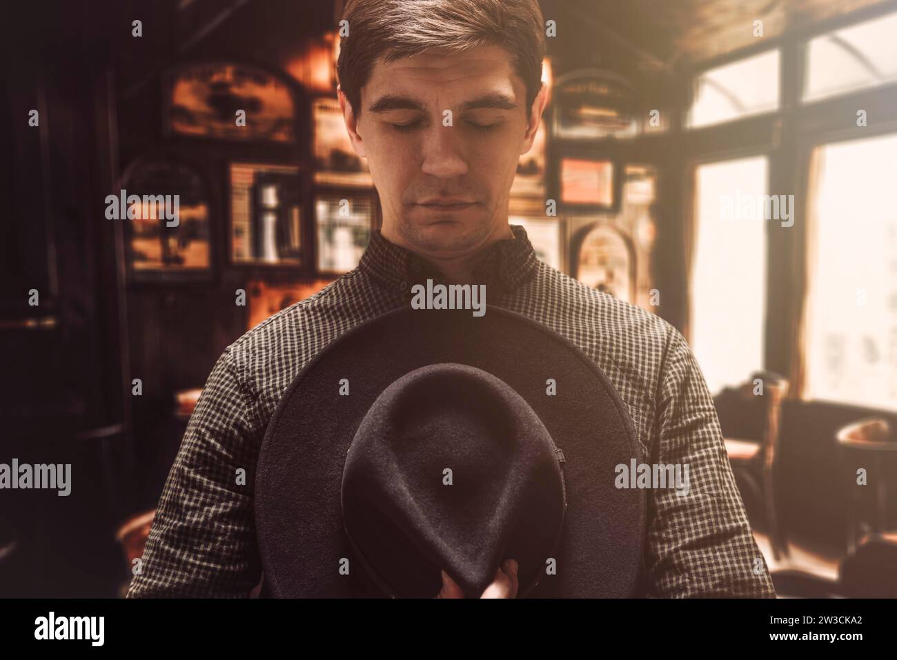 Ritratto di un uomo che tiene il cappello al petto. Stile Cowboy. Saloon. Supporti misti Foto Stock
