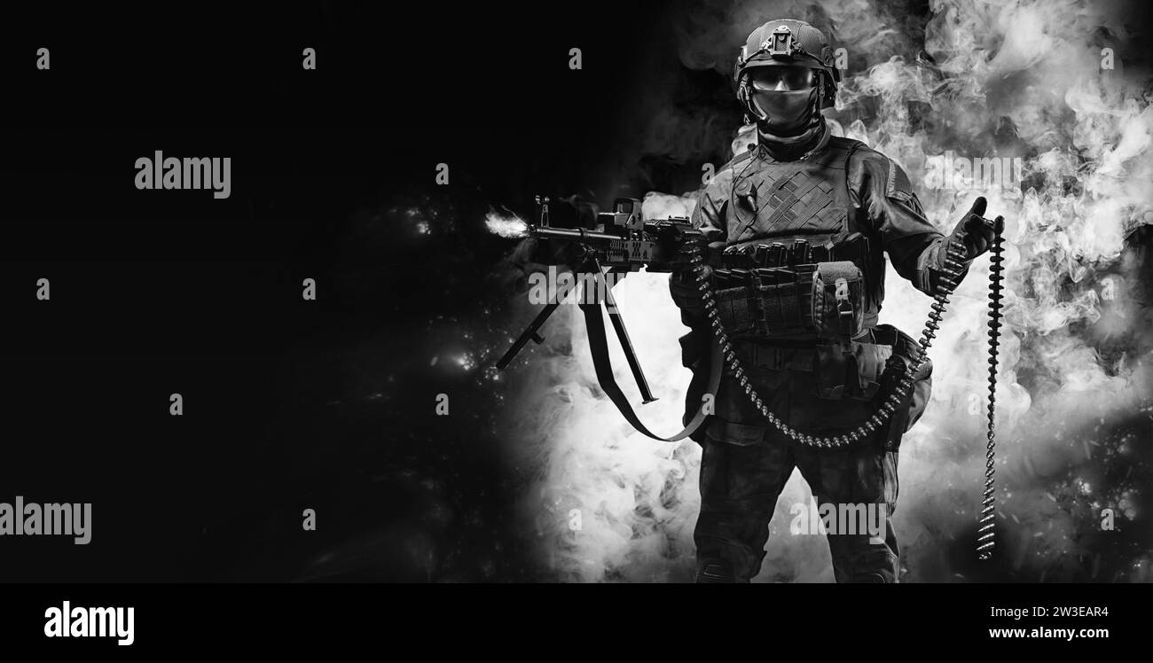 Ritratto di un combattente di un'unità speciale. Giace a terra e spara da una mitragliatrice pesante. Concetto SWAT. Supporti misti Foto Stock