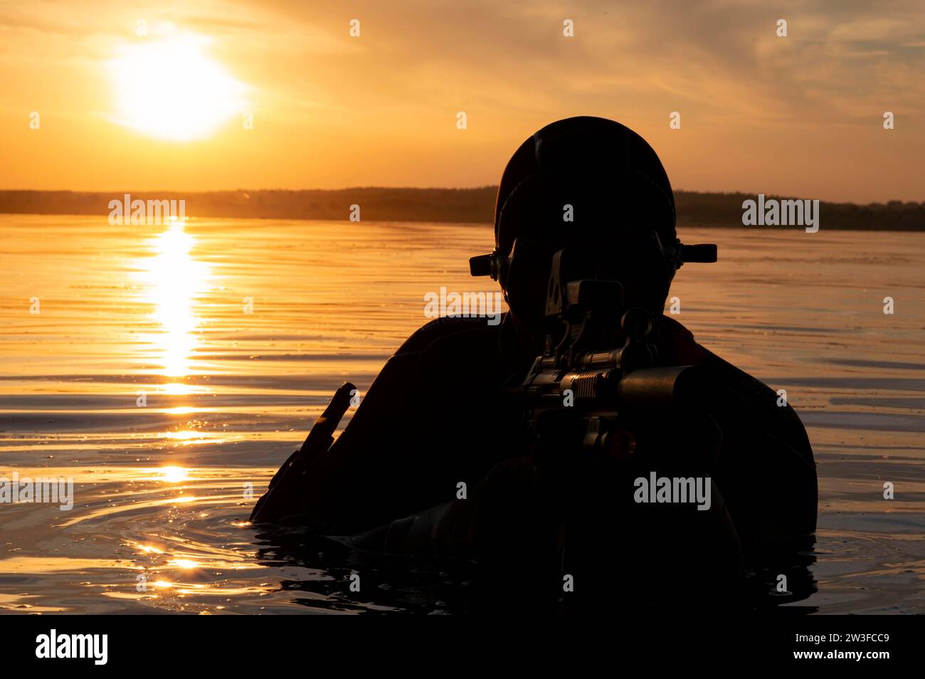 Il combattente di un'unità speciale lascia l'acqua e si prepara per l'inizio dell'operazione. Supporti misti. Il concetto di instabilità nel mondo Foto Stock