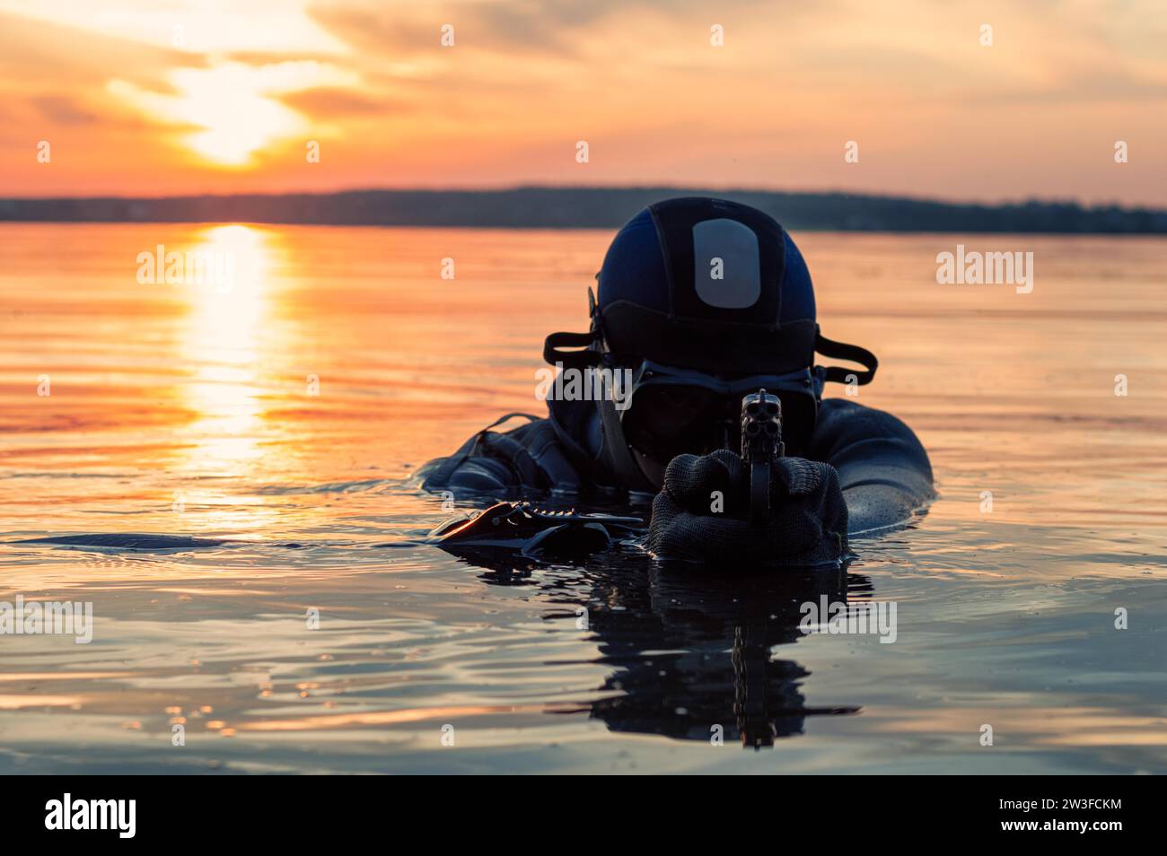 Il combattente di un'unità speciale lascia l'acqua e si prepara per l'inizio dell'operazione. Supporti misti. Il concetto di instabilità nel mondo Foto Stock