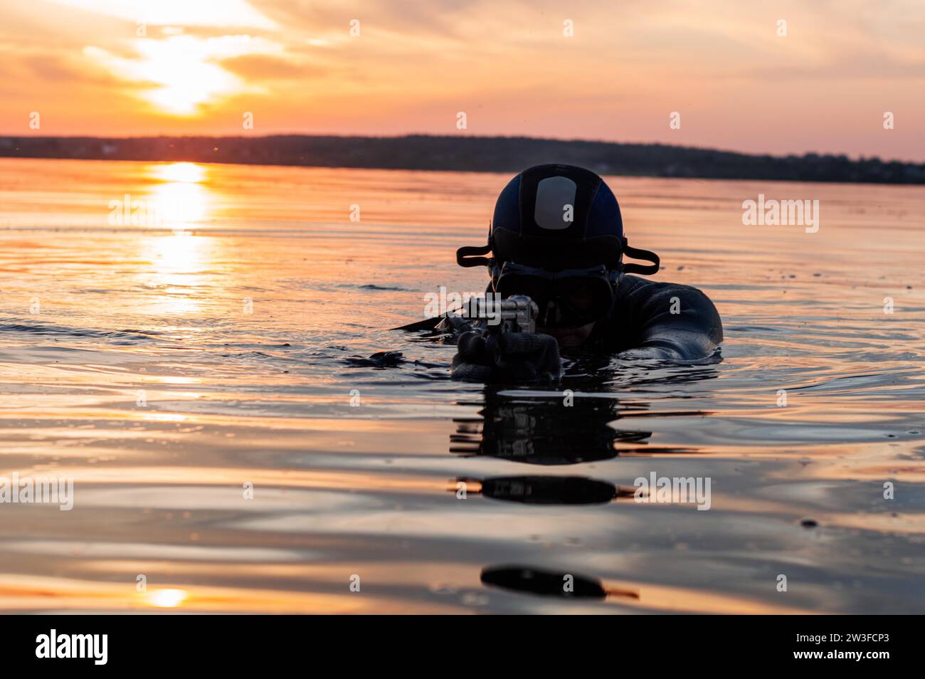 Il combattente di un'unità speciale lascia l'acqua e si prepara per l'inizio dell'operazione. Supporti misti. Il concetto di instabilità nel mondo Foto Stock
