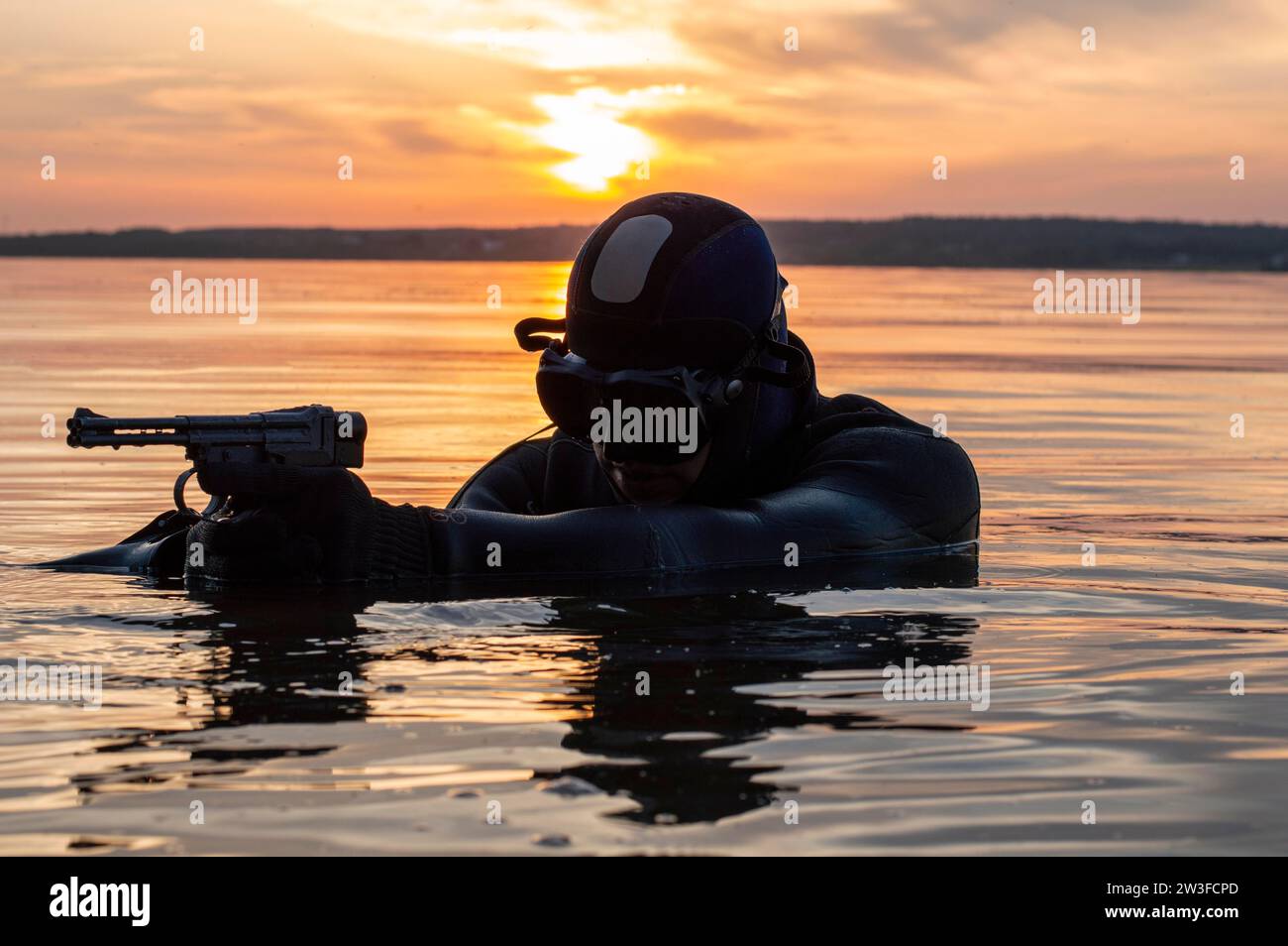 Il combattente di un'unità speciale lascia l'acqua e si prepara per l'inizio dell'operazione. Supporti misti. Il concetto di instabilità nel mondo Foto Stock