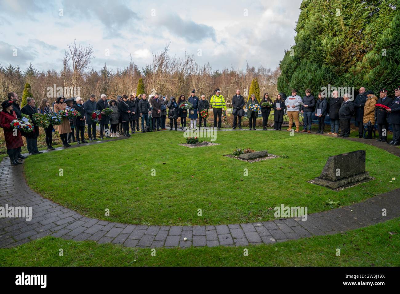 La gente si riunisce per una cerimonia in occasione del 35° anniversario dell'attentato di Lockerbie al Memorial Garden, cimitero di Dryfesdale, Lockerbie. Il 21 dicembre 1988, il volo Pan Am 103 esplose sopra la città di Dumfries and Galloway, 40 minuti dopo il suo volo da Londra a New York. Tutti i 259 passeggeri e l'equipaggio furono uccisi, tra cui 35 studenti dell'Università di Siracusa, insieme a 11 residenti di Lockerbie. Data immagine: Giovedì 21 dicembre 2023. Foto Stock