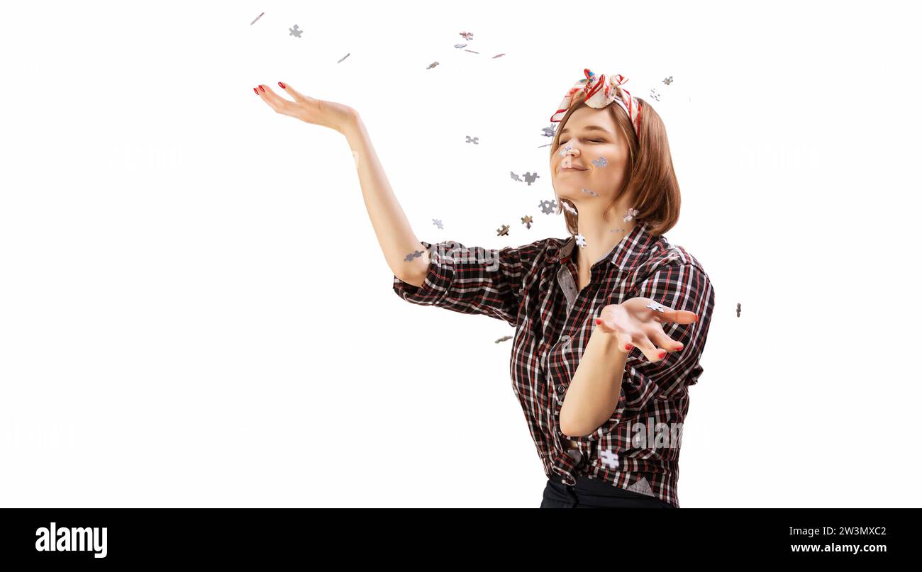 Simpatica ragazza spruzza intorno ai puzzle. Il concetto di scuola prescolare e di scuola a casa. Divertenti giochi da tavolo. Supporti misti Foto Stock