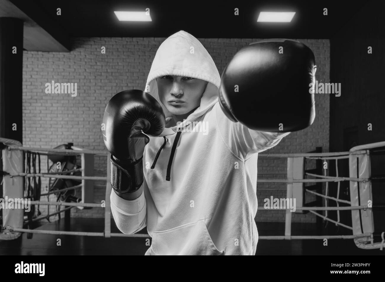 Pugilato brutale da atleta sul ring con una felpa bianca con cappuccio. Concetto di arti marziali miste. Elevata qualità delle immagini Foto Stock