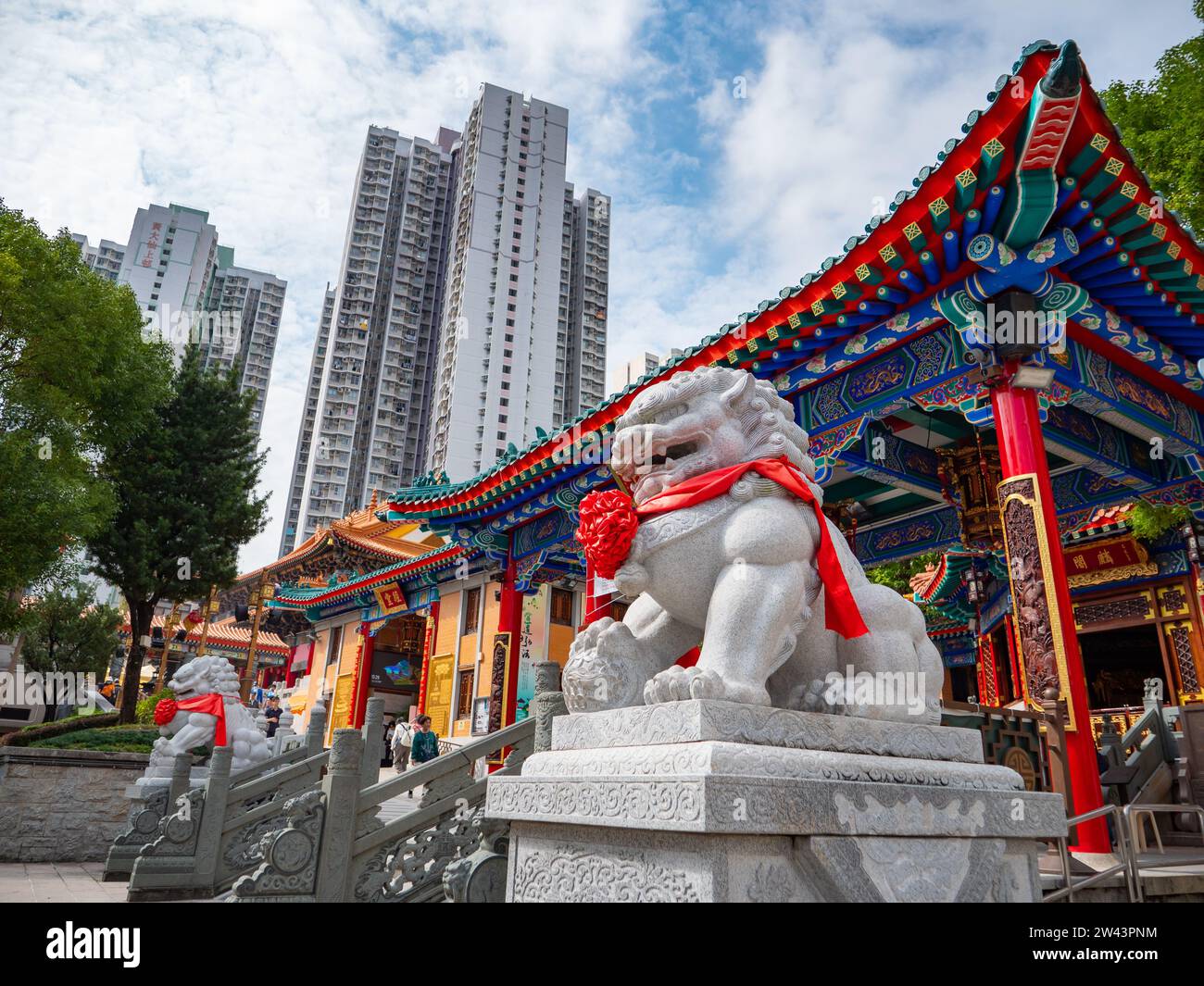 13 novembre 2023. Tempio di Wong Tai sin - area di Wong Tai sin, Hong Kong. Statua color pietra del cane leone di fronte all'edificio del tempio di Wong Tai sin Foto Stock