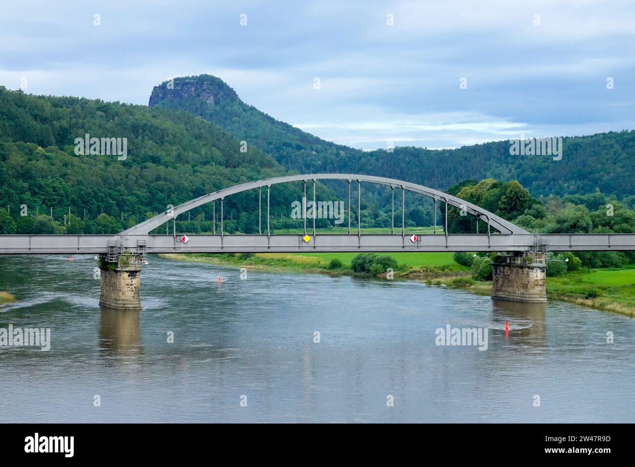 Ponte ferroviario ad arco in acciaio nella valle del fiume Elba, monte Lilienstein sullo sfondo Foto Stock