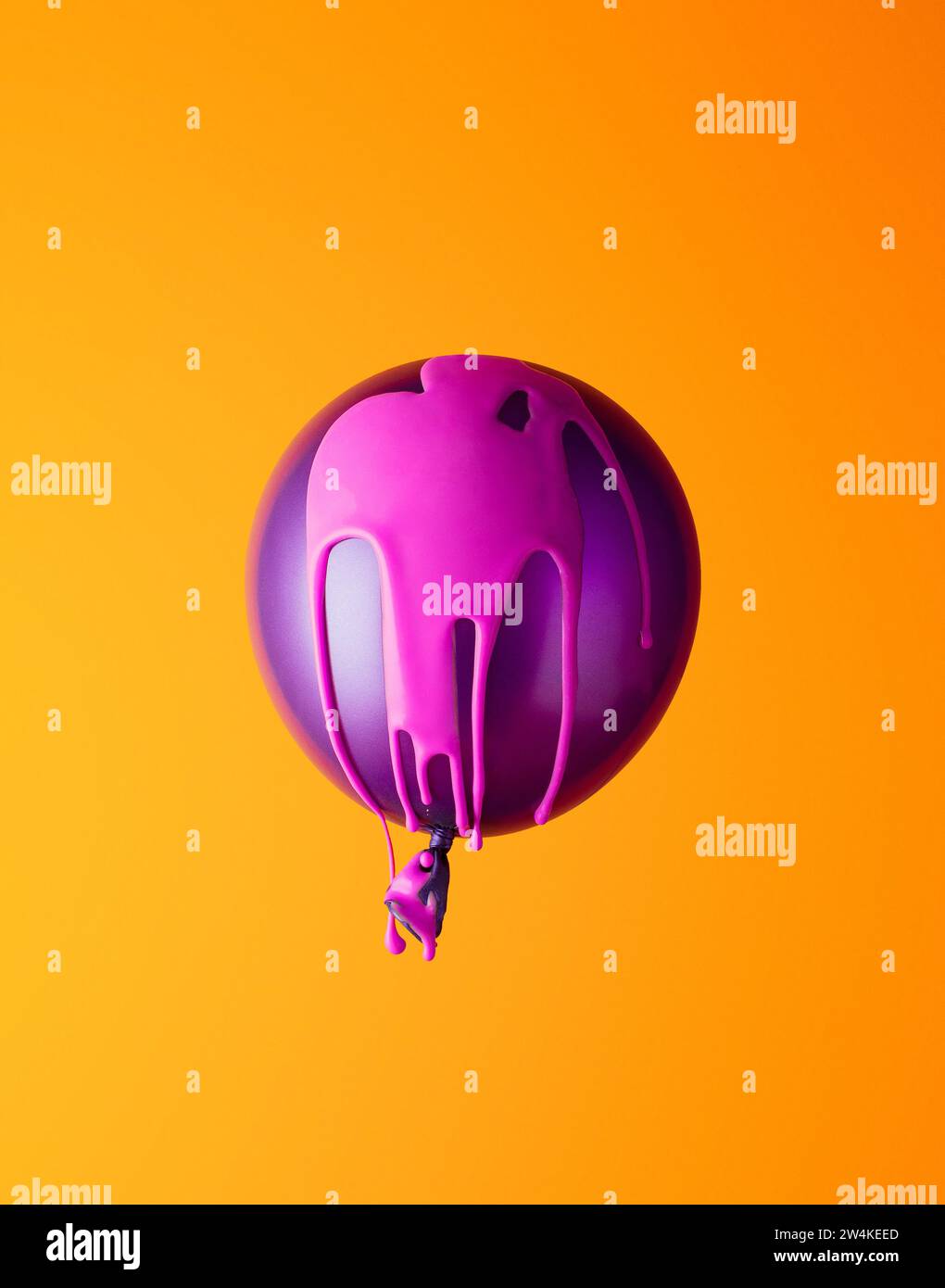 Ballon di elio ricoperto di vernice rosa su sfondo arancione. Minimo. Foto Stock