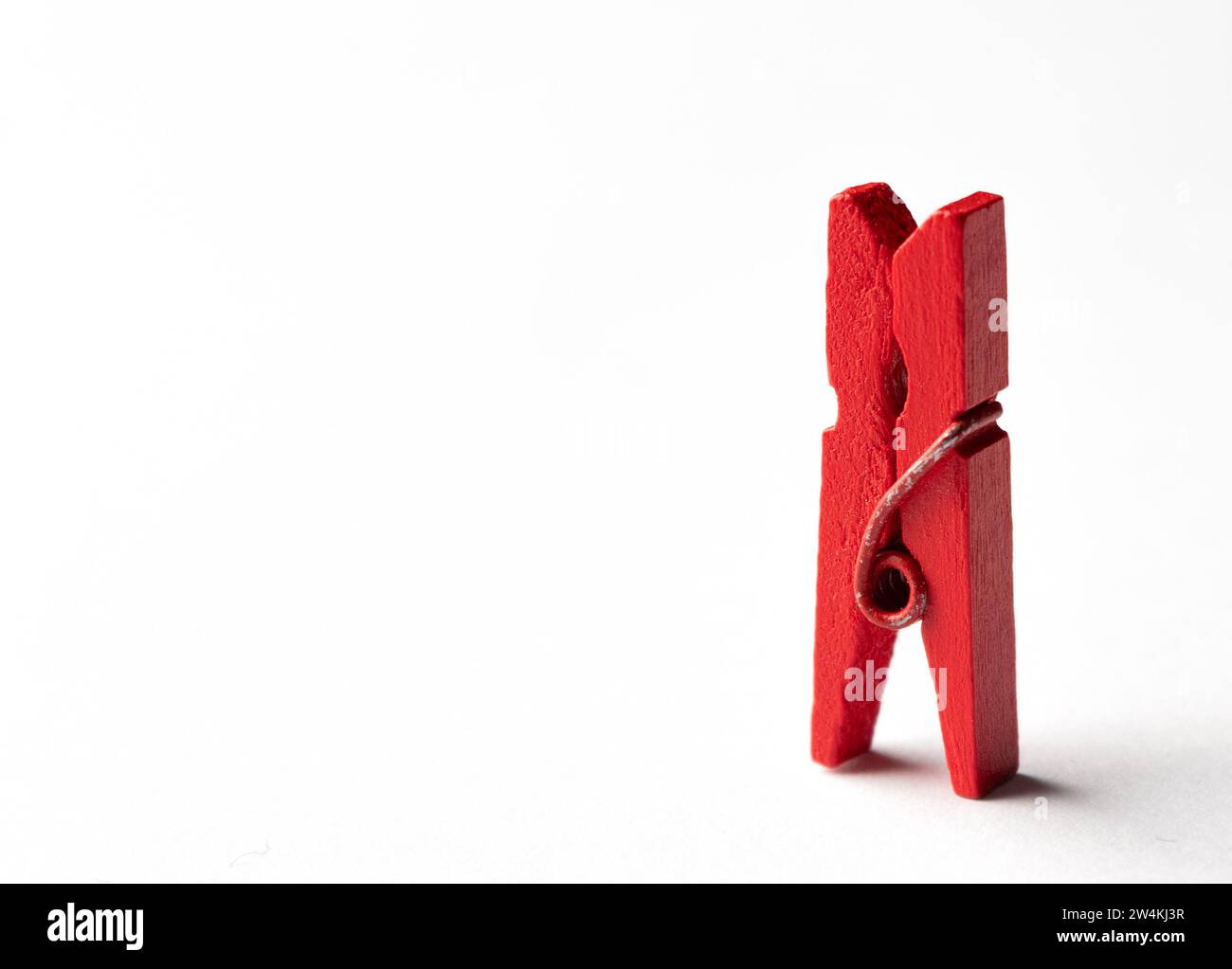 Clothespin di legno rosso su sfondo bianco. Minamal Concept. Foto Stock