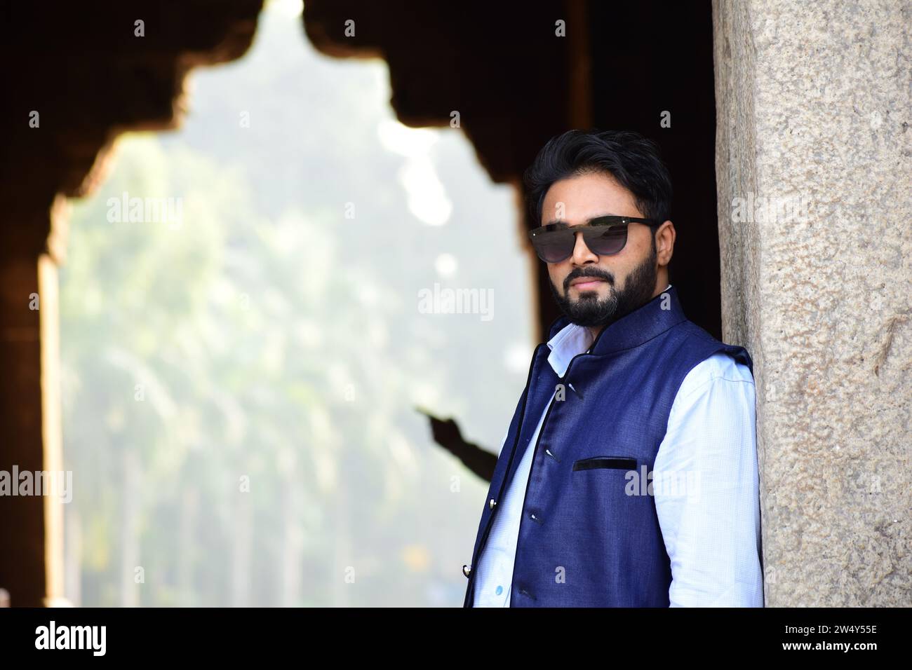 Elegante modello indiano uomo in abiti casual camicia bianca nera con giacca blu e occhiali da sole foto perfetta per uso commerciale. Foto Stock