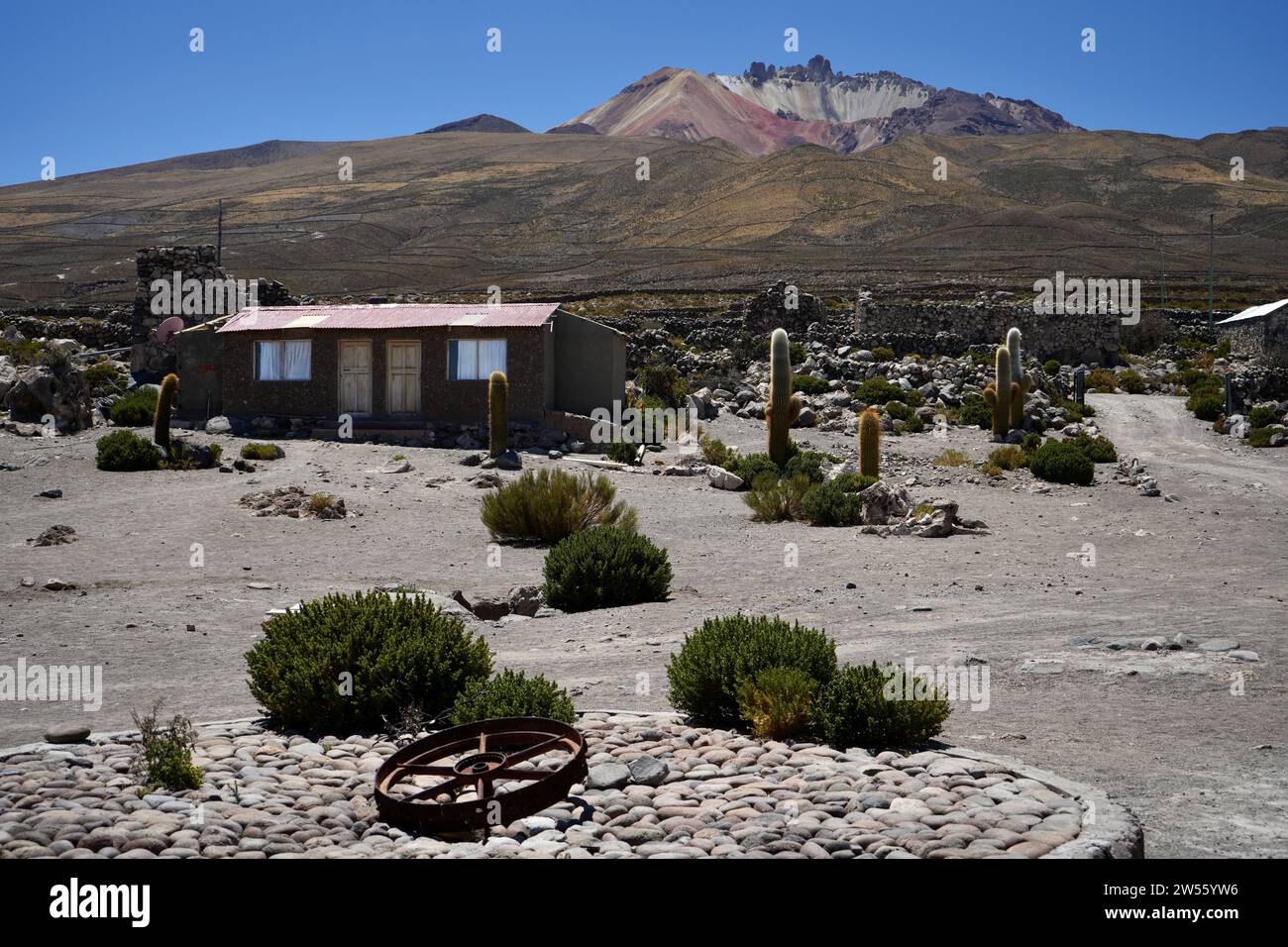 Edifici nel villaggio con il vulcano Tunupa alle spalle. Coqueza Canton, Bolivia. Foto Stock