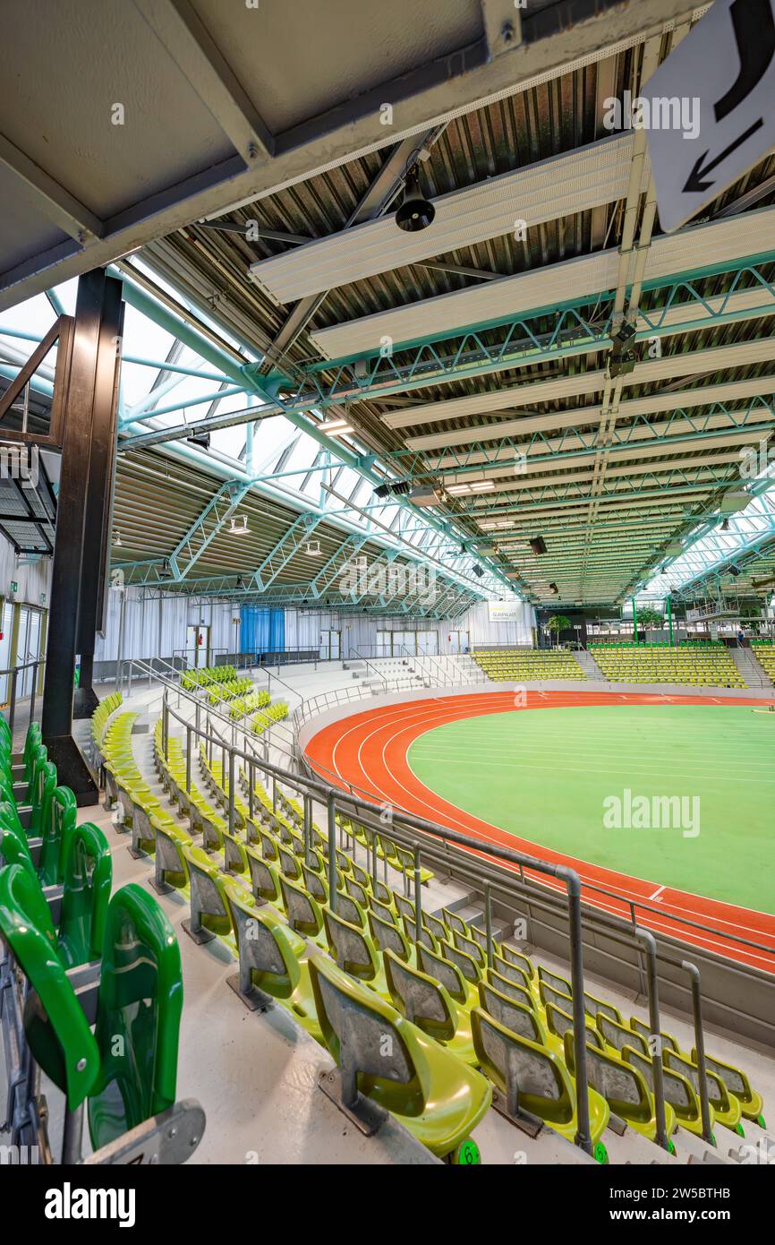 Vista interna di uno stadio vuoto con file verdi di posti a sedere e una pista di atletica, Glaspalast, Sindelfingen, Germania Foto Stock