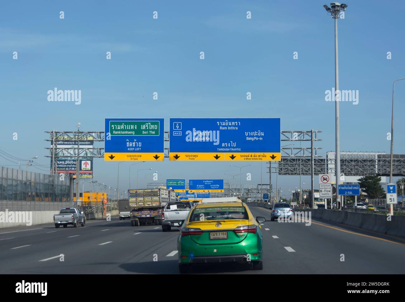 sopra un'autostrada a samat prakan, bangkok, thailandia, le indicazioni in thai e inglese danno indicazioni per le destinazioni locali Foto Stock