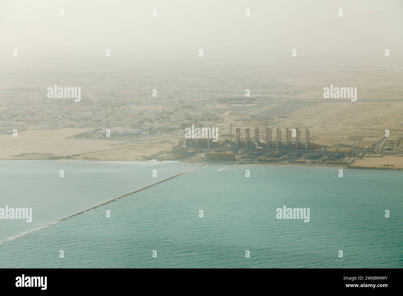 Vista aerea di una raffineria di gas naturale liquido e di una centrale elettrica sulla costa di Doha, Qatar, sul Golfo Persico, vista dall'alto in una giornata di fumo Foto Stock