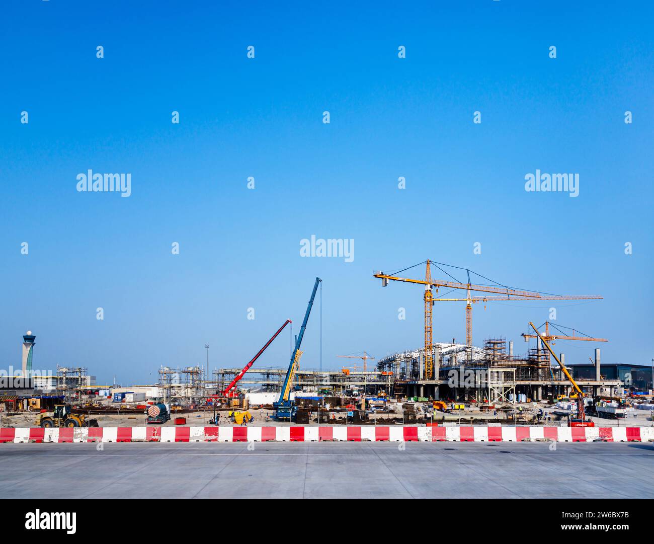 Nuovi lavori di costruzione in corso e gru a torre gialle Liebherr presso l'aeroporto internazionale Hamad di Doha, Qatar, Medio Oriente Foto Stock