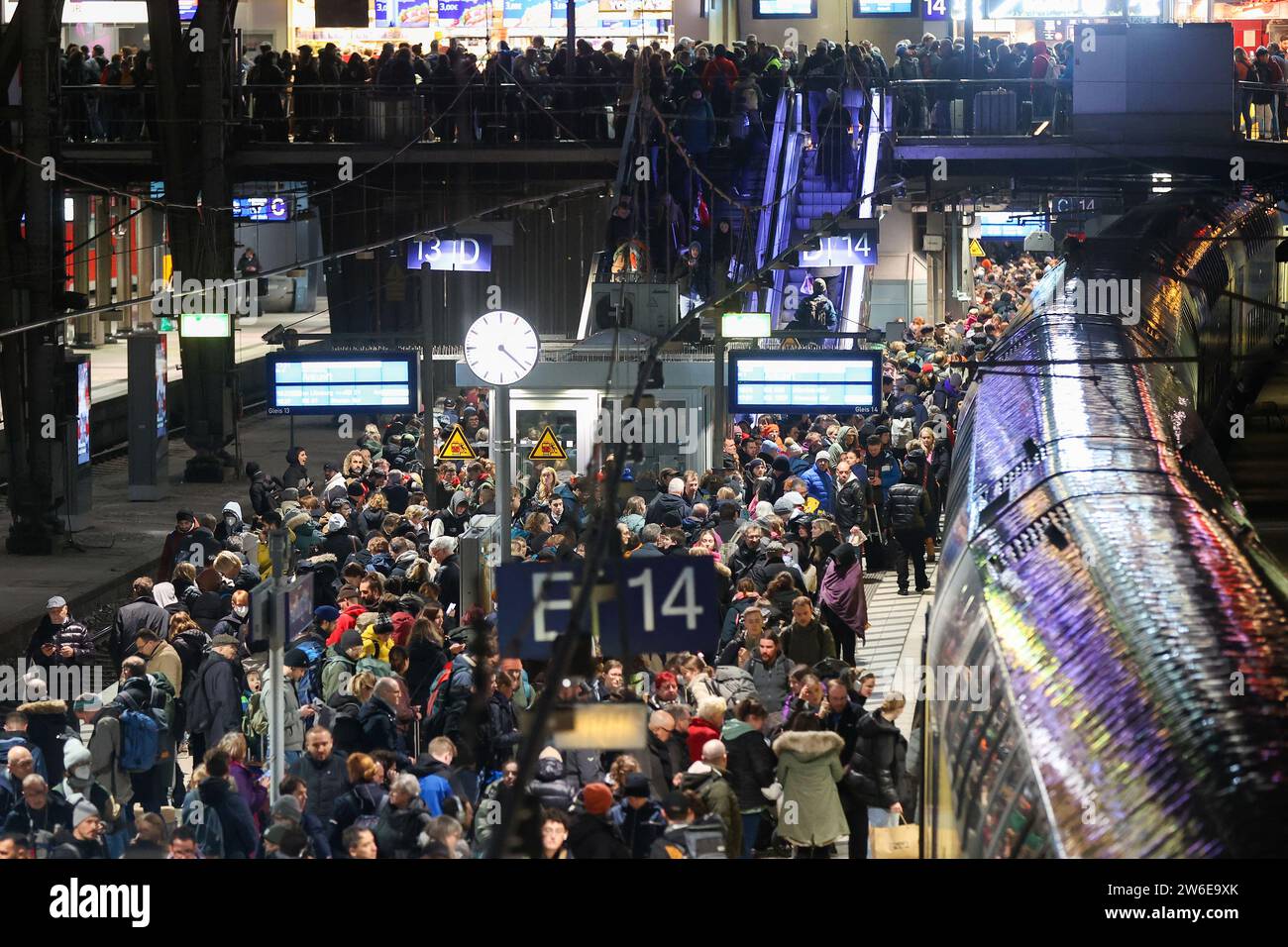 Amburgo, Germania. 21 dicembre 2023. Numerosi viaggiatori aspettano il loro treno su un binario completo presso la stazione principale. La tempesta "Zoltan" ha causato cancellazioni e ritardi ai servizi a lunga distanza della Deutsche Bahn il giovedì. I collegamenti Eurocity, Intercity e ICE ad Amburgo, Schleswig-Holstein e bassa Sassonia sono interessati, come annunciato dalla Deutsche Bahn giovedì pomeriggio. Credito: Bodo Marks/dpa/Alamy Live News Foto Stock