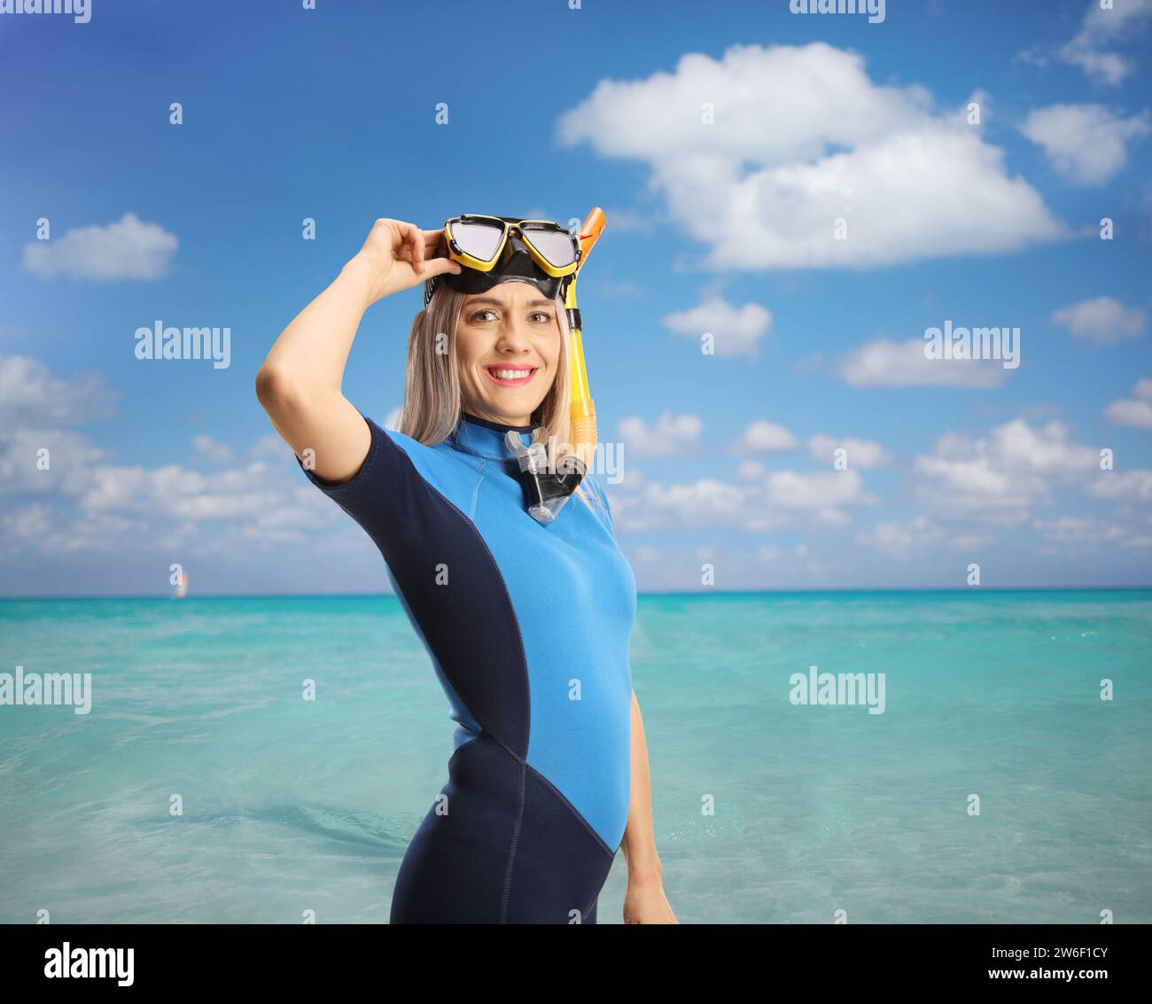 Giovane donna in muta con una maschera subacquea che guarda la macchina fotografica Foto Stock