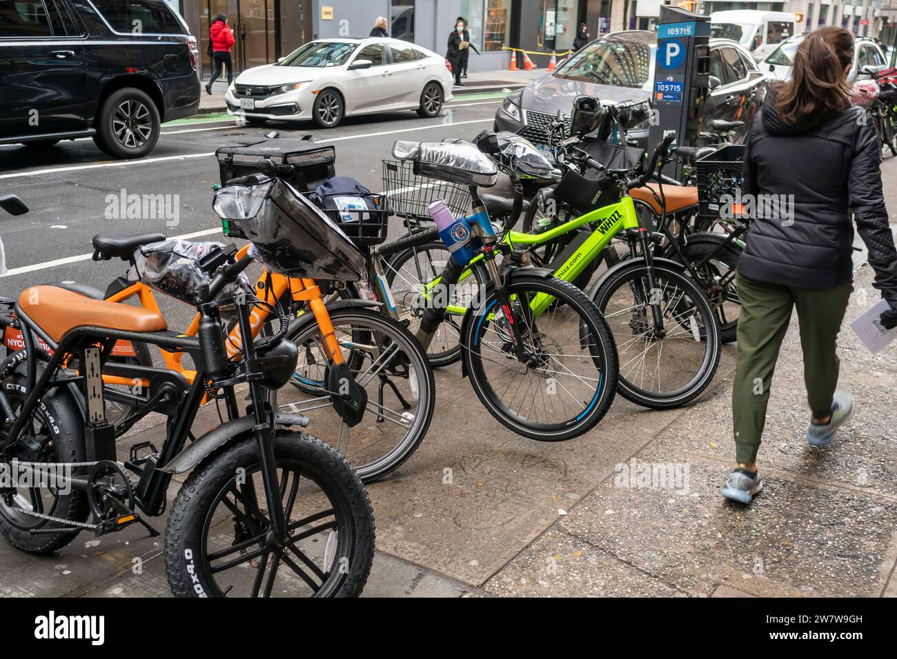 Una collezione di e-bike dei deliverymen parcheggiate fuori da un ristorante a Chelsea a New York lunedì 18 dicembre 2023. (© Richard B. Levine) Foto Stock