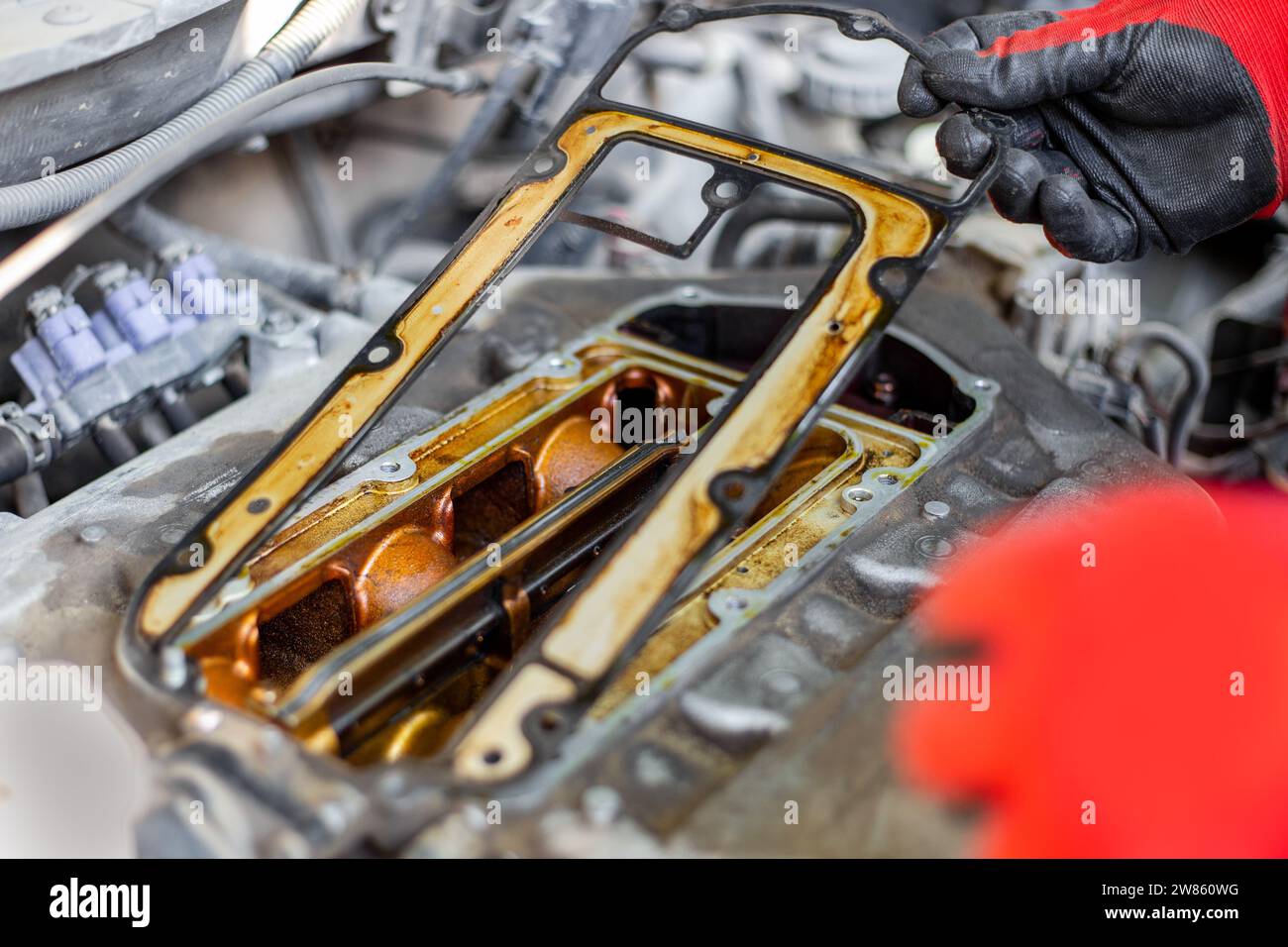 Riparazioni auto. un meccanico automatico smonta il meccanismo della valvola di distribuzione del gas. Foto Stock