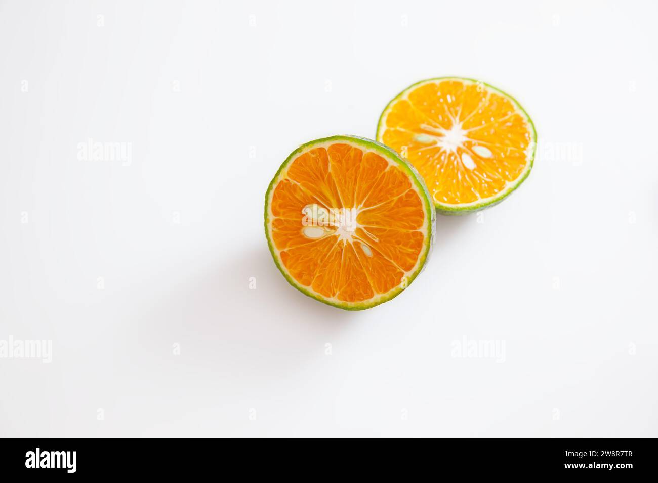 Arancia con buccia verde tagliata a metà isolata su sfondo bianco Foto Stock