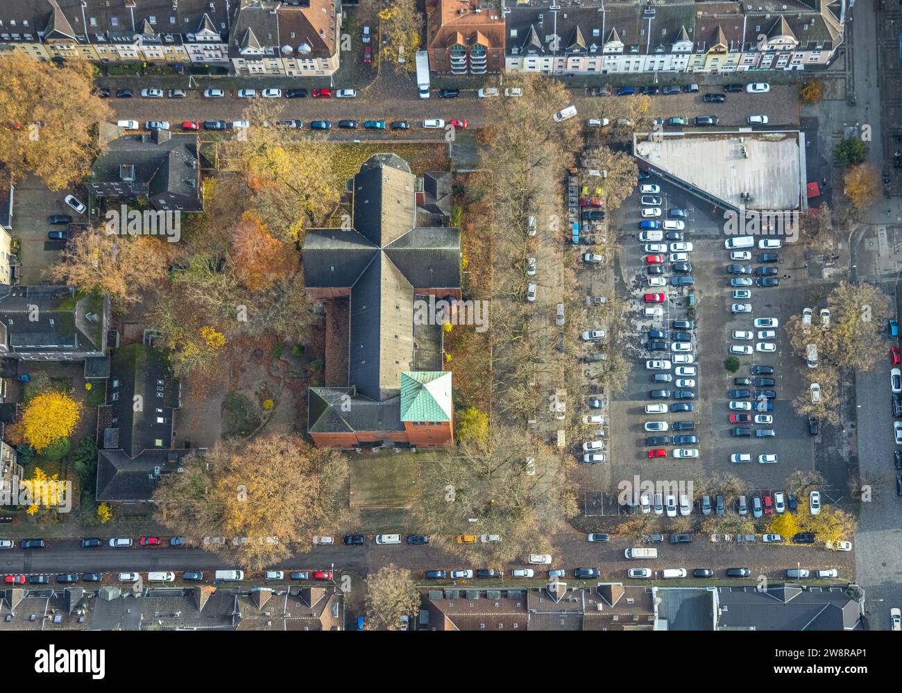 Vista aerea, immagine verticale di St Chiesa di Michele in Michaelplatz con parcheggi, circondati da alberi decidui autunnali, Wanheimerort, Duisburg, Foto Stock