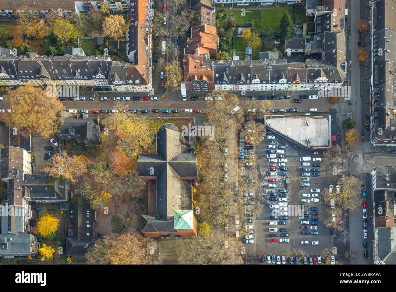 Vista aerea, immagine verticale di St Chiesa di Michele in Michaelplatz con parcheggi, circondati da alberi decidui autunnali, Wanheimerort, Duisburg, Foto Stock