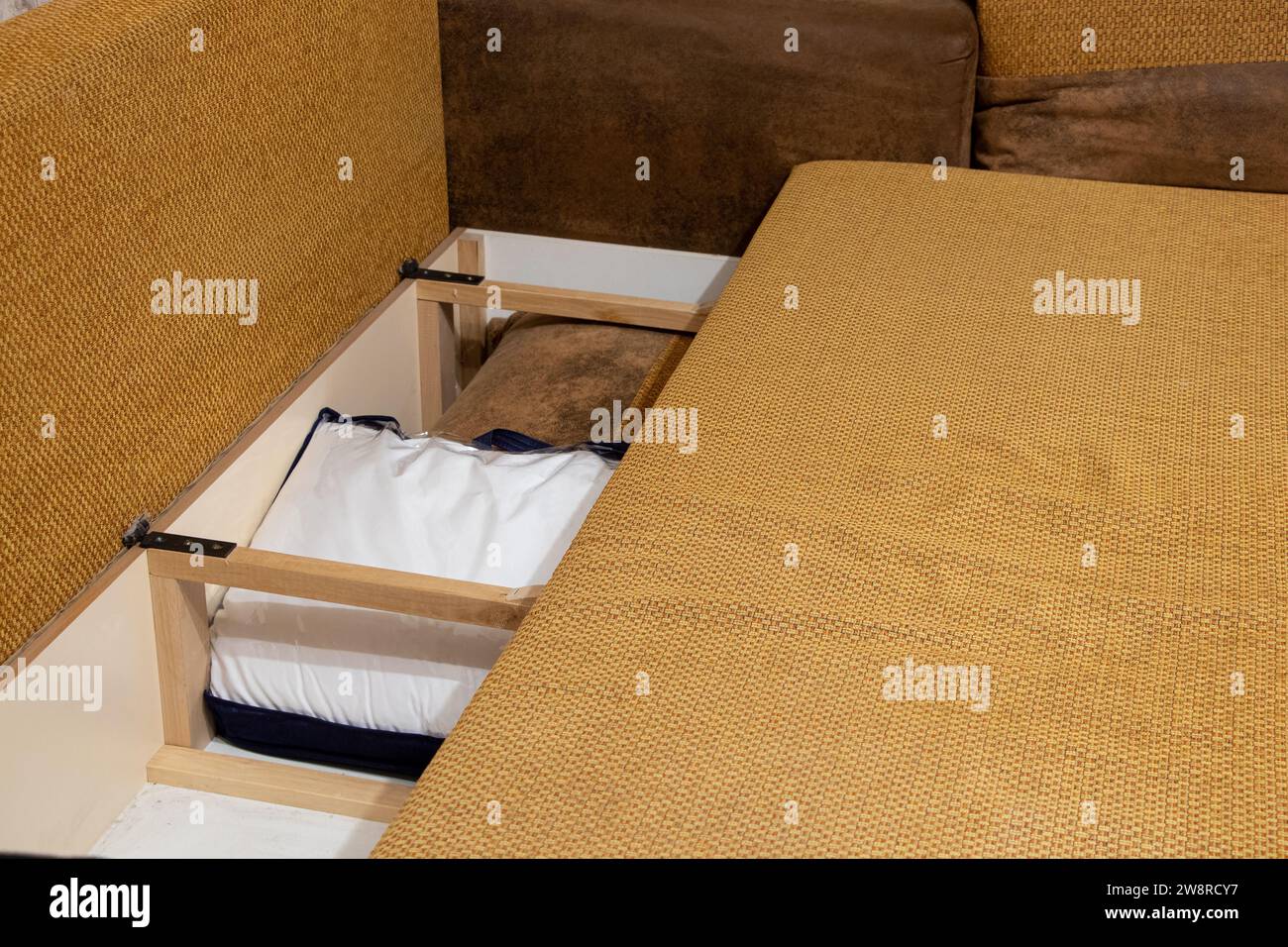 Vano portaoggetti all'interno del divano dove i cuscini sono a casa nell'appartamento, mobili della camera da letto in primo piano Foto Stock