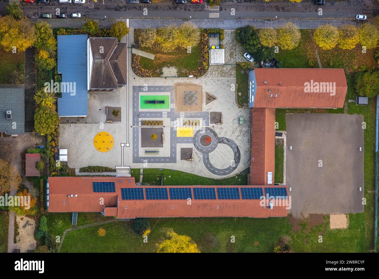 Vista aerea, ripresa verticale, forme e colori, cortile scolastico e scuola elementare a Erzbahn con tetto solare, asilo protestante Hüllen, surroun Foto Stock