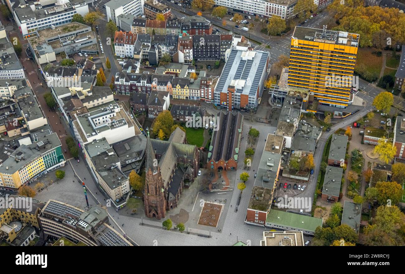 Vista aerea, zona pedonale della città vecchia con St Chiesa cattolica di Agostino, alto edificio giallo Targobank, circondato da un albero deciduo autunnale Foto Stock