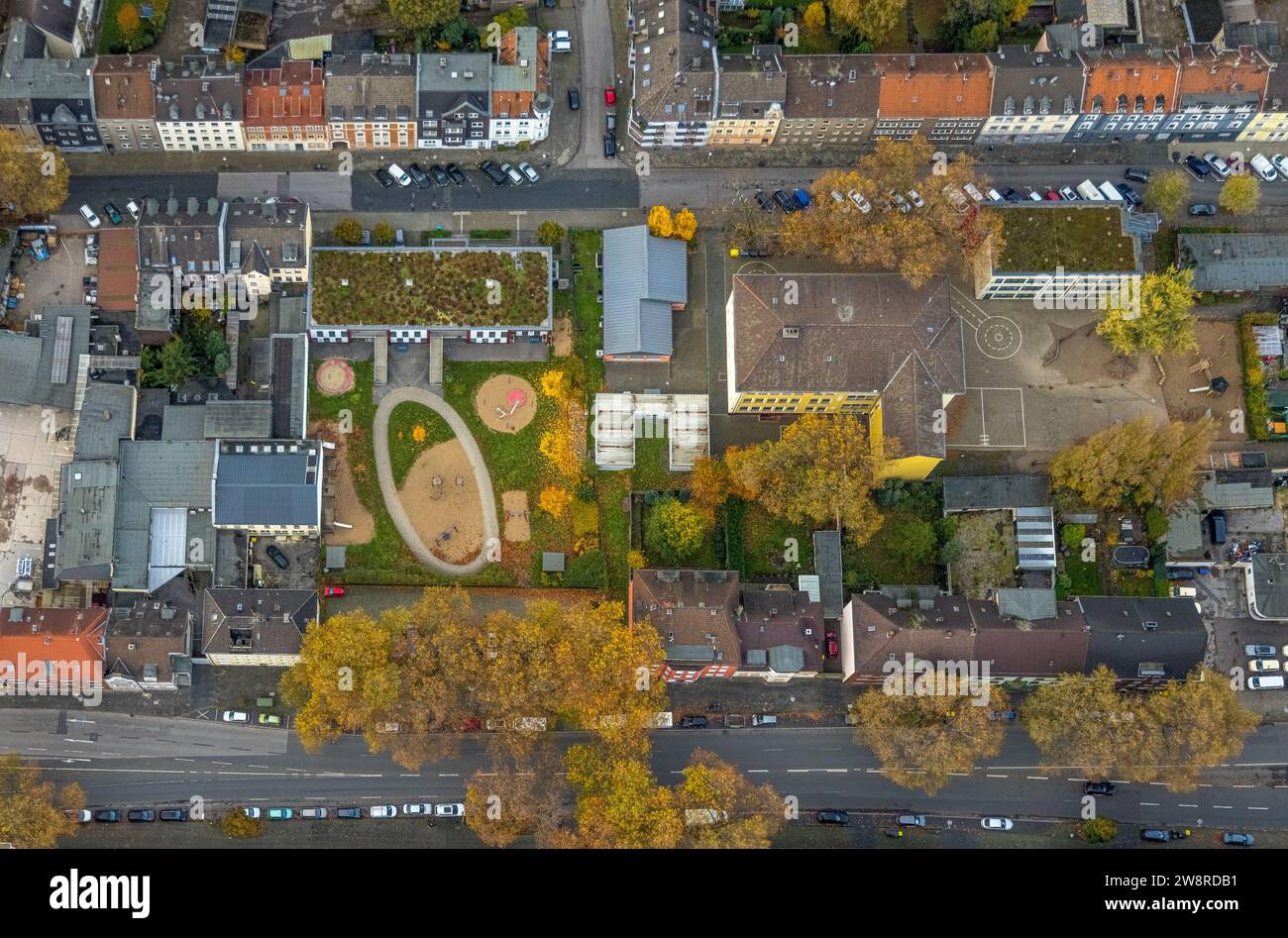 Vista aerea, immagine verticale di forme e colori, asilo municipale Kita Florastraße con parco giochi per bambini, scuola elementare GGS Sternschule Foto Stock