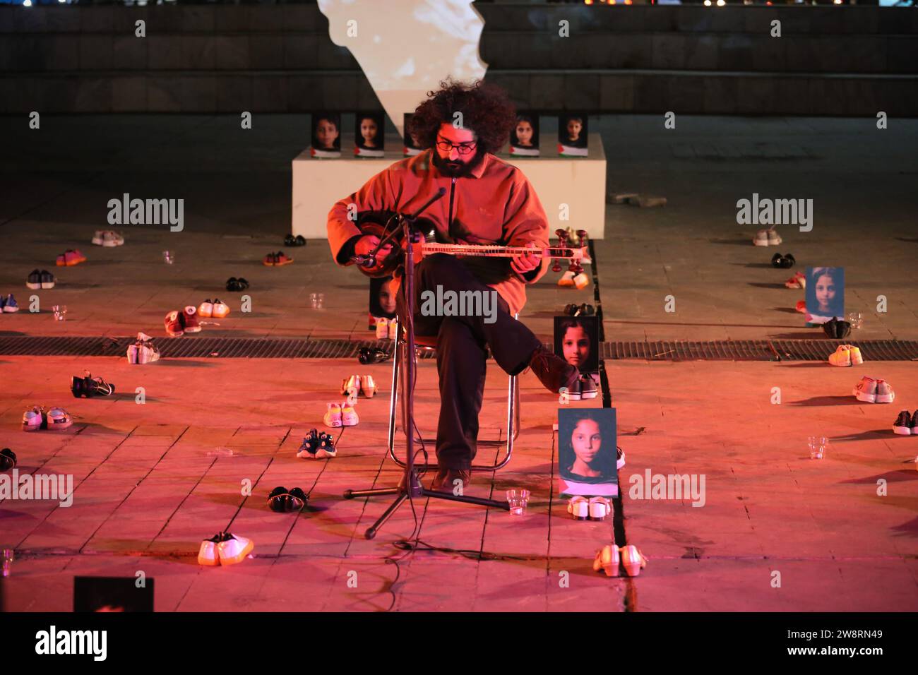 Teheran, Iran. 21 dicembre 2023. Un musicista iraniano suona il Tar (strumento a corda) tra gli oggetti e le immagini che ritraggono bambini deceduti a Gaza durante una campagna pro-Palestina nella piazza Hafte-TIR, nel centro di Teheran. Migliaia di persone sono morte da quando i militanti di Hamas hanno lanciato un attacco contro Israele dalla Striscia di Gaza il 7 ottobre, e le operazioni israeliane a Gaza e in Cisgiordania che l'hanno seguita. (Immagine di credito: © Rouzbeh Fouladi/ZUMA Press Wire) SOLO USO EDITORIALE! Non per USO commerciale! Foto Stock