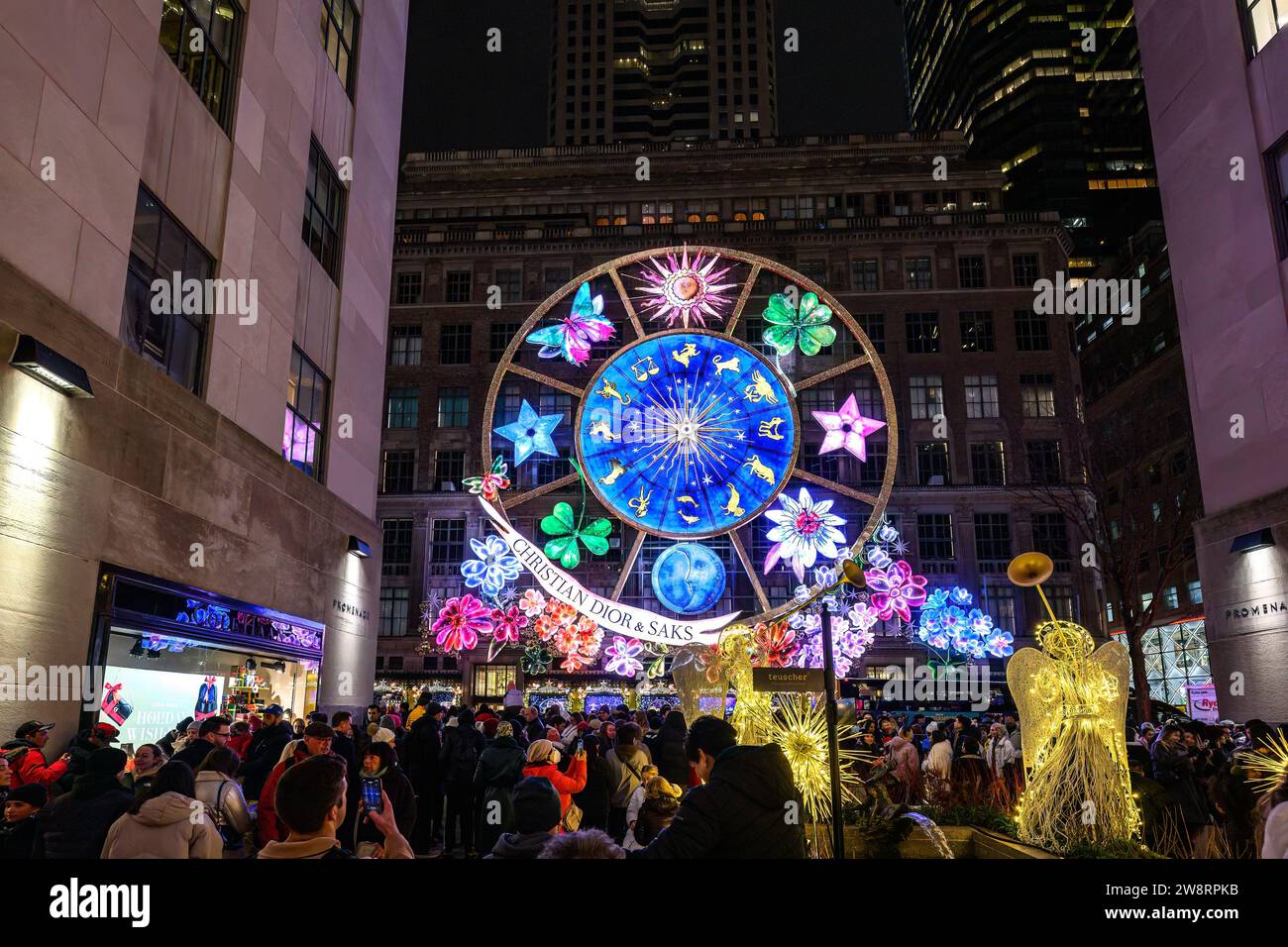 New York, USA, 20 dicembre 2023. La gente guarda uno spettacolo di luci e suoni spettacolari durante le vacanze sulla Saks Fifth Avenue a New York City, il Rockefeller Center A. Foto Stock