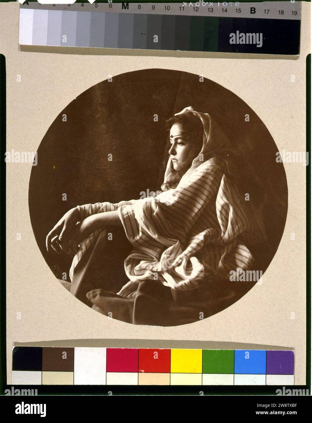 Giovane donna in Medio Oriente e in costume jeweled archetto, seduto sul pavimento Foto Stock