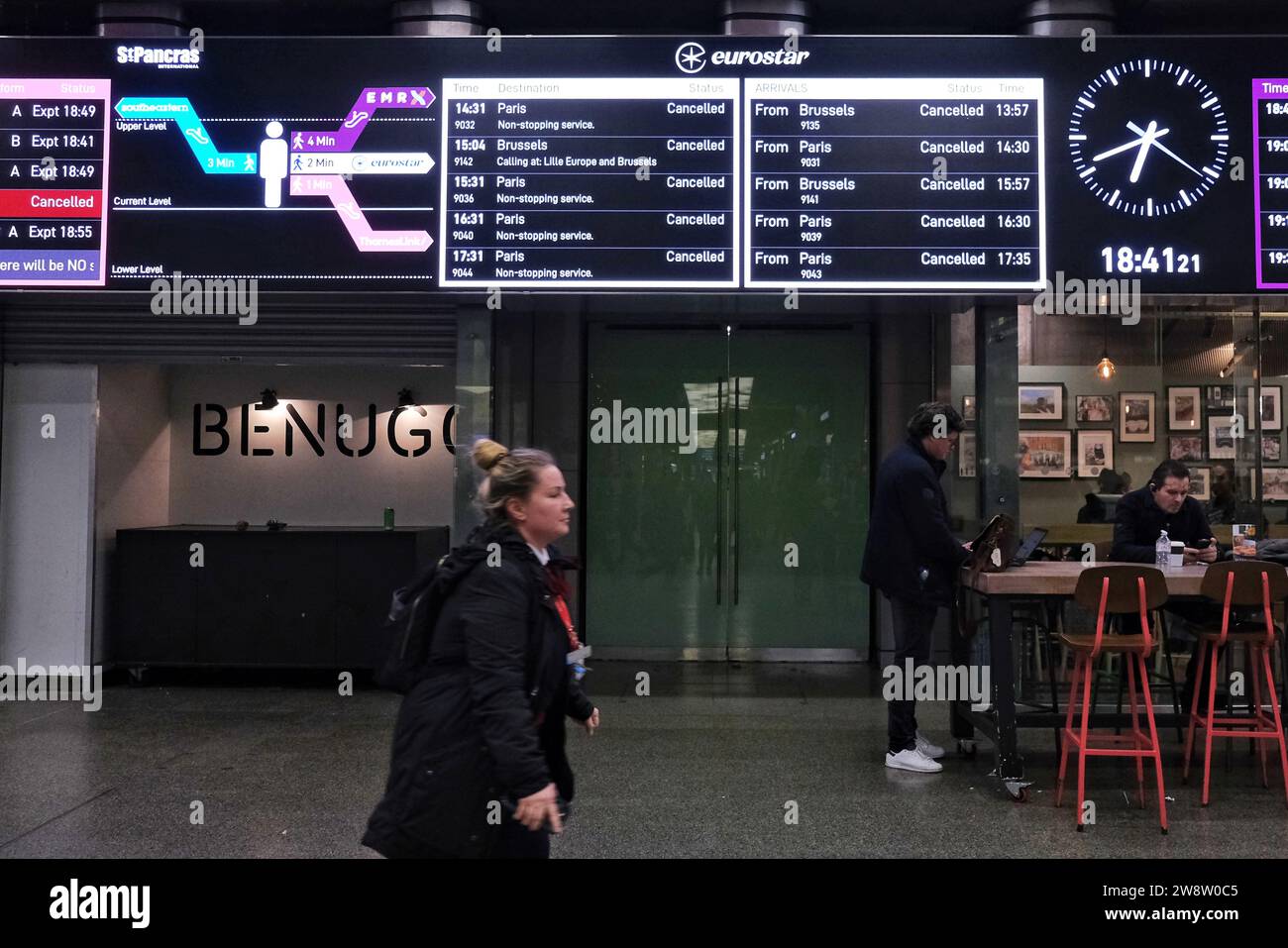 Londra, Regno Unito. 21 dicembre 2023. Un membro del personale dell'Eurostar corre davanti a una bacheca informativa che mostra servizi annullati. Le interruzioni di viaggio continuano presso il terminal Eurostar di St Pancras, dove uno sciopero precedente durò da mezzogiorno fino alle prime ore della sera, quando i lavoratori francesi organizzarono un'uscita inaspettata, causando la cancellazione di dozzine di treni. I servizi non dovrebbero riprendere fino a venerdì, interessando migliaia di passeggeri. Credito: Fotografia dell'undicesima ora/Alamy Live News Foto Stock