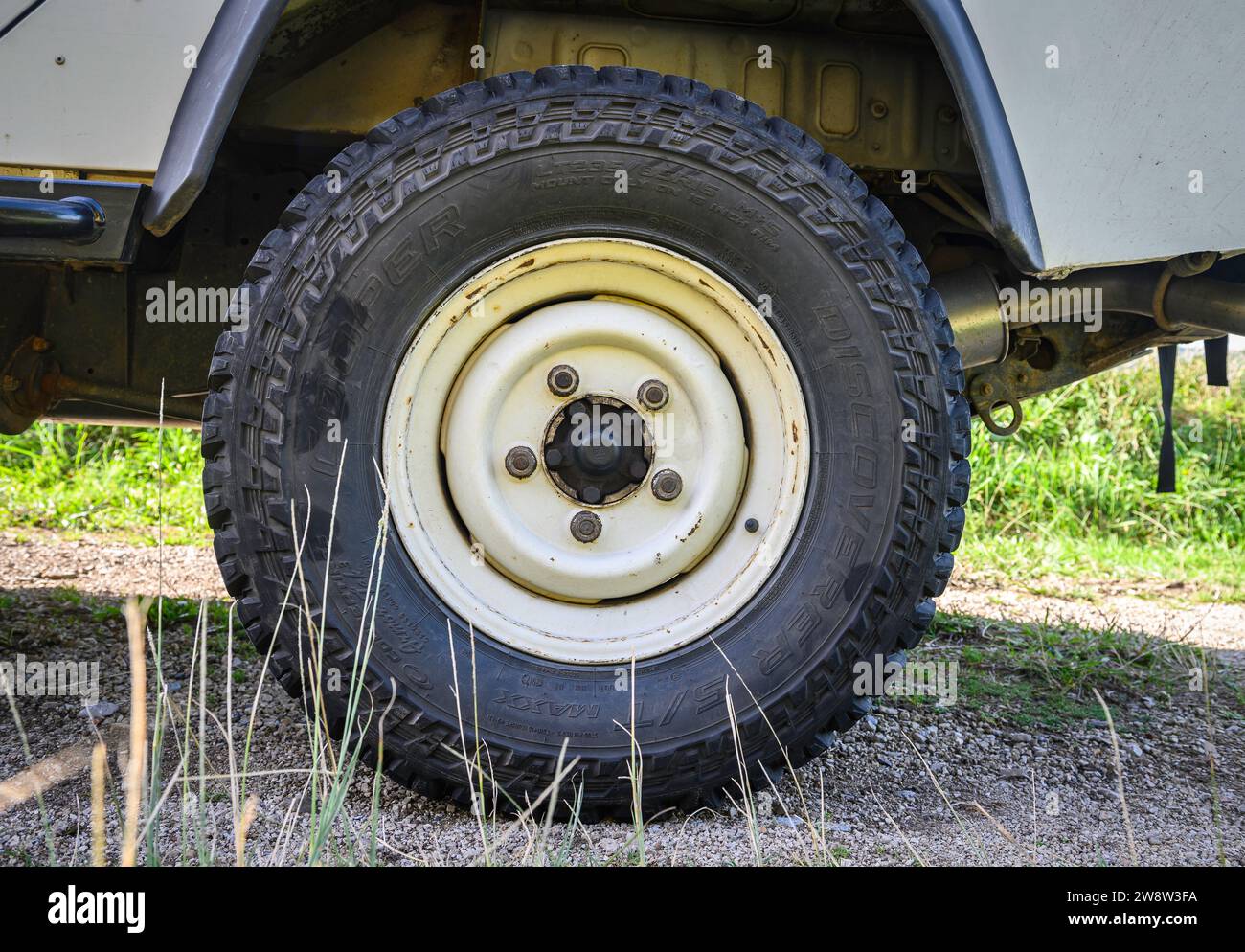 "Primo piano della ruota posteriore sinistra di un Land Rover Defender con pneumatici fango." Foto Stock