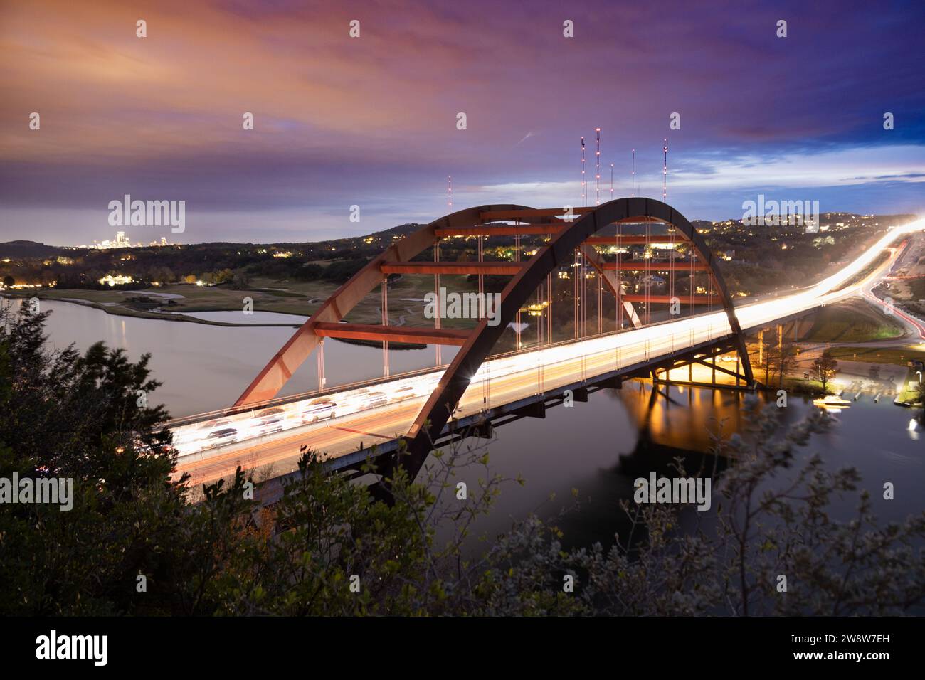 Una lunga esposizione al tramonto del Pennybacker Bridge (360 Bridge) ad Austin, Texas, mentre il traffico scorre. Le luci della città possono essere viste sullo sfondo Foto Stock